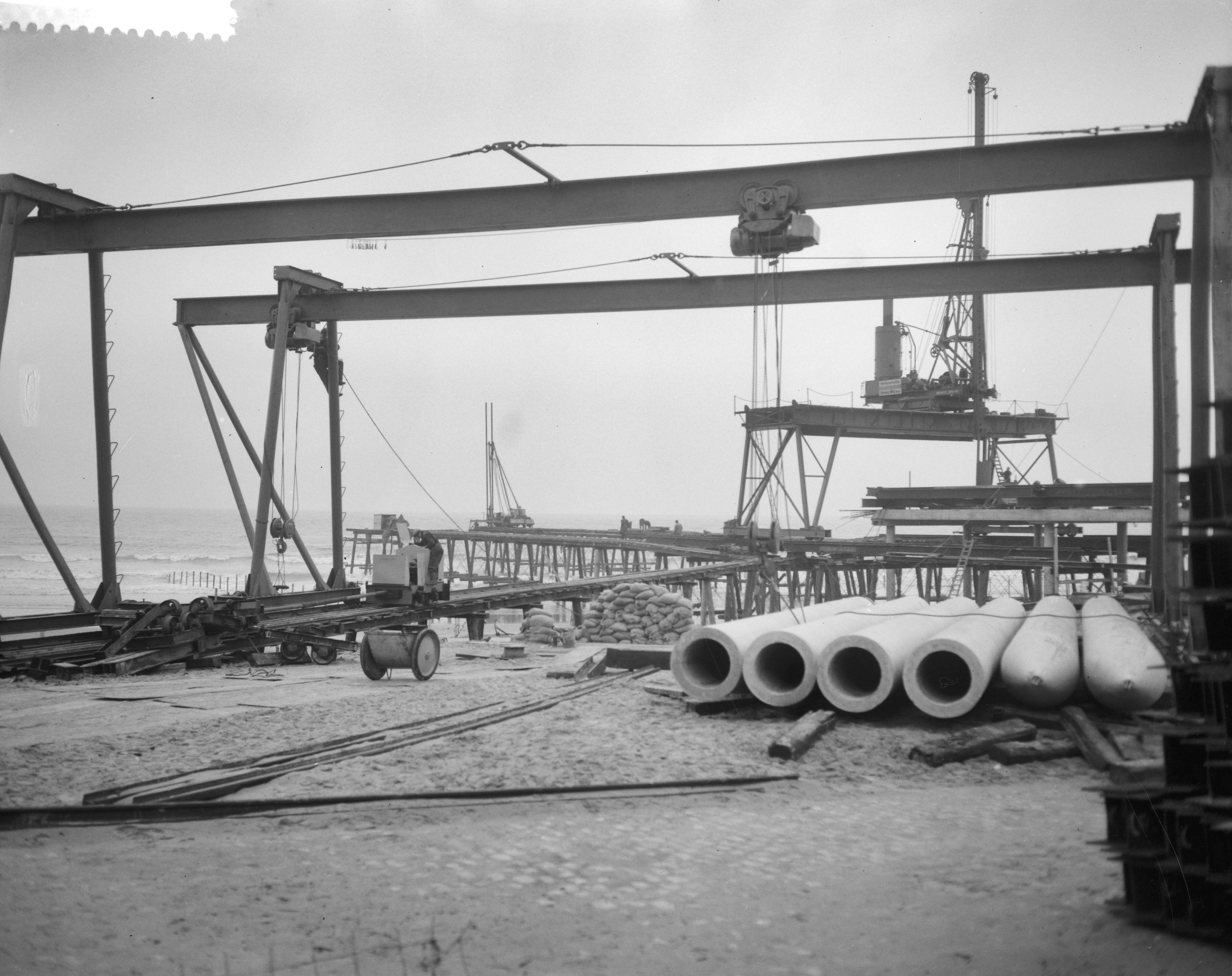 Fotocollectie Anefo — Bouw pier te Scheveningen — Foto: Bilsen, Joop van / Anefo. Licentie: Set B: Rechtenvrij / Publiek Domein. Bron: Nationaal Archief. http://hdl.handle.net/10648/a9a8c274-d0b4-102d-bcf8-003048976d84