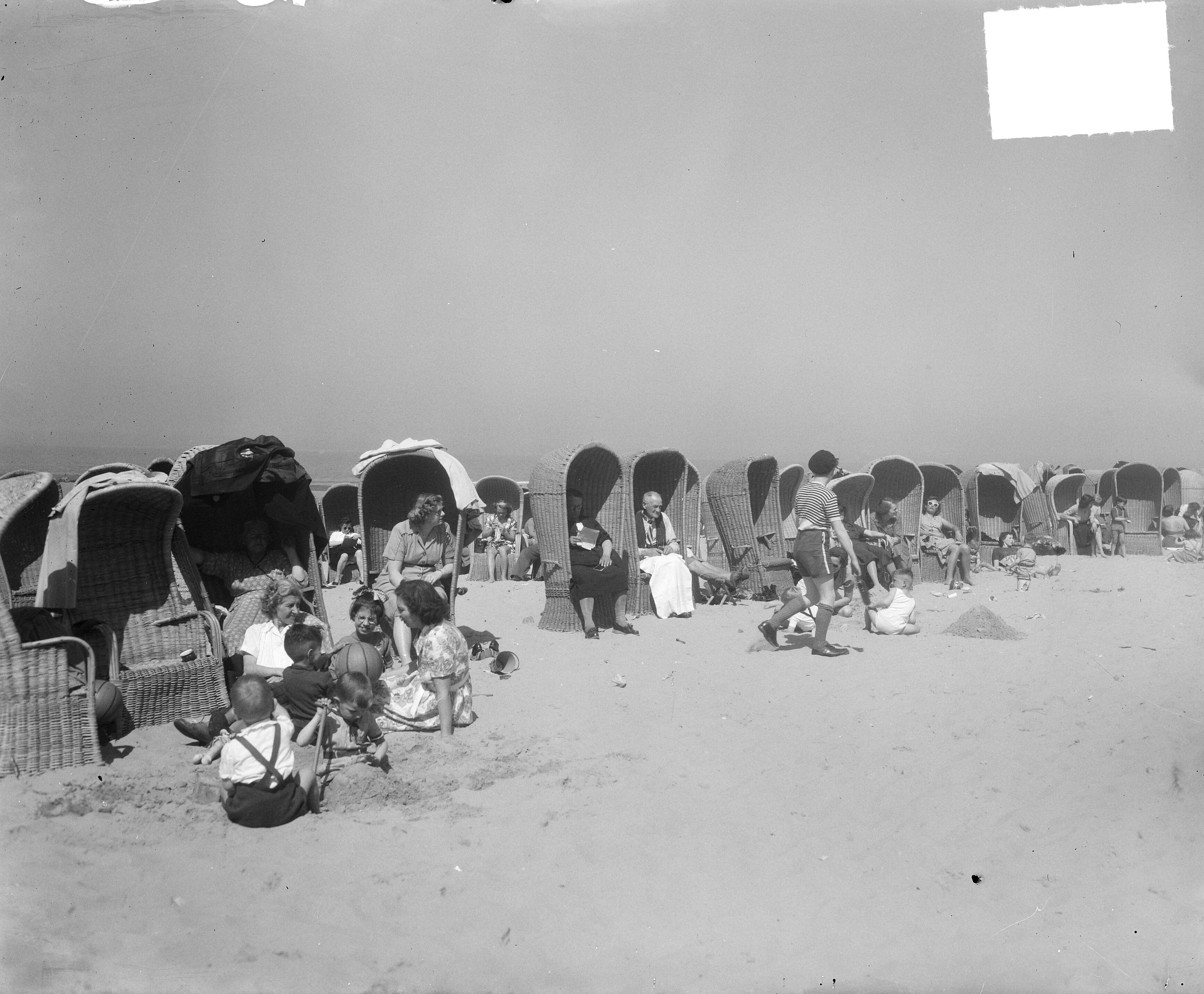 Fotocollectie Anefo — Voorjaar in Scheveningen in badstoelen — Foto: Duinen, H. van / Anefo. Licentie: Set B: Rechtenvrij / Publiek Domein. Bron: Nationaal Archief. http://hdl.handle.net/10648/a8e918de-d0b4-102d-bcf8-003048976d84