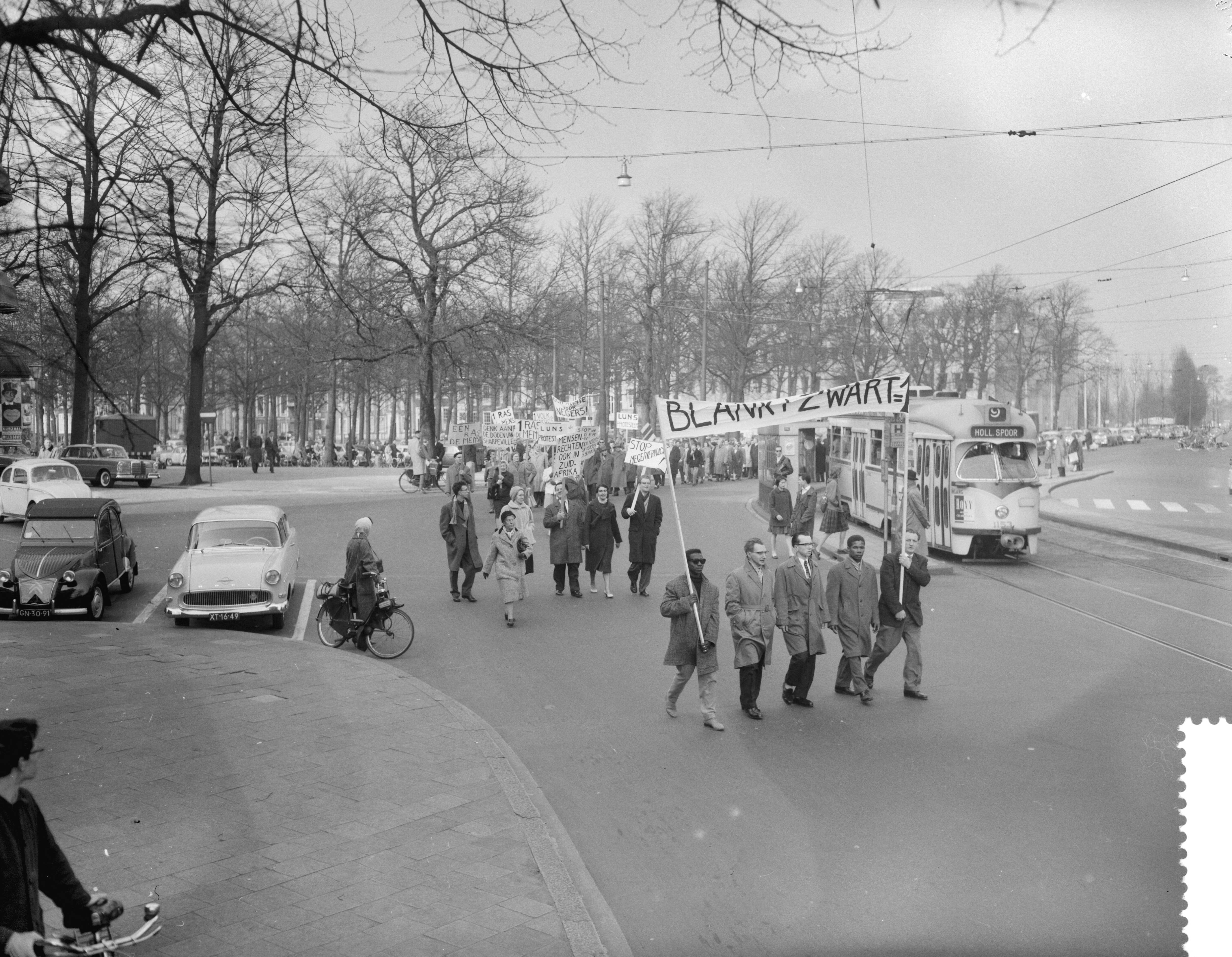 Fotocollectie Anefo — Protestdemonstratie tegen de Apartheidspolitiek van Zuid-Afrika in Den Haag. De stoet met spandoeken op weg — Foto: Behrens, Herbert F. / Anefo. Licentie: Set B: Rechtenvrij / Publiek Domein. Bron: Nationaal Archief. http://hdl.handle.net/10648/a9ab92ce-d0b4-102d-bcf8-003048976d84
