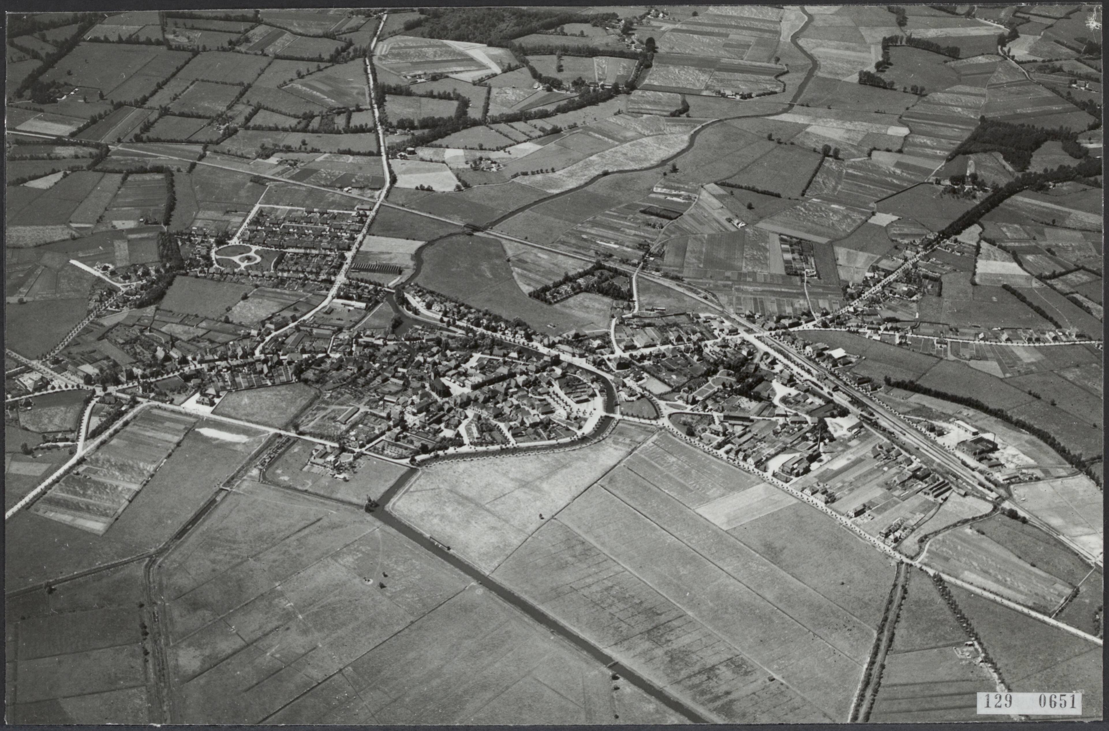 Steden [RVD] — Luchtopname. Locatie onbekend [plaats aan een meander in een deels gekanaliseerde rivier, rechts een spoorlijn met spoorwegstation met emplacement] — Foto: KLM Aerocarto / Rechtenvrij. Licentie: Set B: Rechtenvrij / Publiek Domein. Bron: Nationaal Archief. http://hdl.handle.net/10648/af475592-d0b4-102d-bcf8-003048976d84