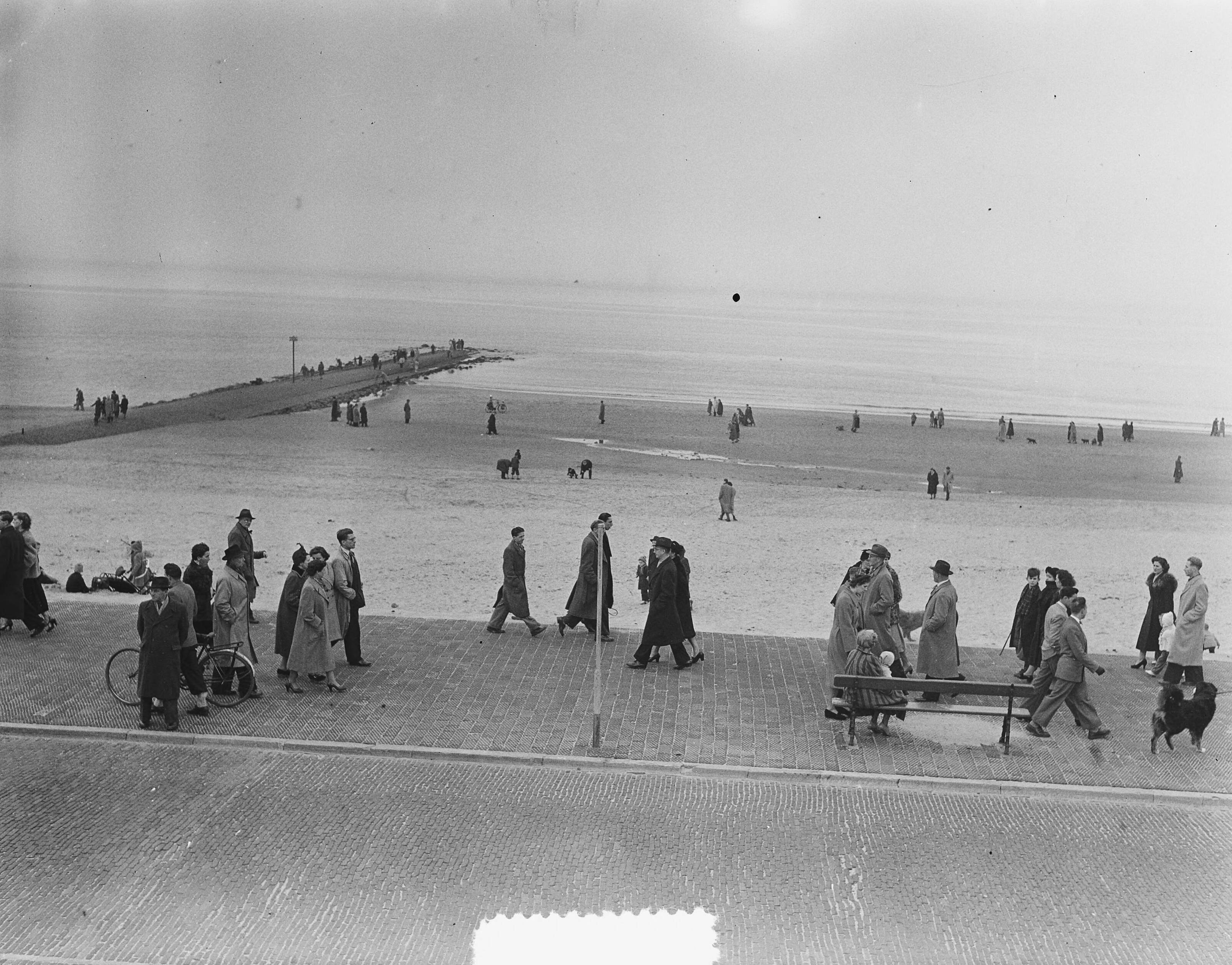 Fotocollectie Anefo — Scheveningen. Voorjaar. Wandelaars op boulevard en strand — Foto: Duinen, H. van / Anefo. Licentie: Set B: Rechtenvrij / Publiek Domein. Bron: Nationaal Archief. http://hdl.handle.net/10648/a8f6bd86-d0b4-102d-bcf8-003048976d84