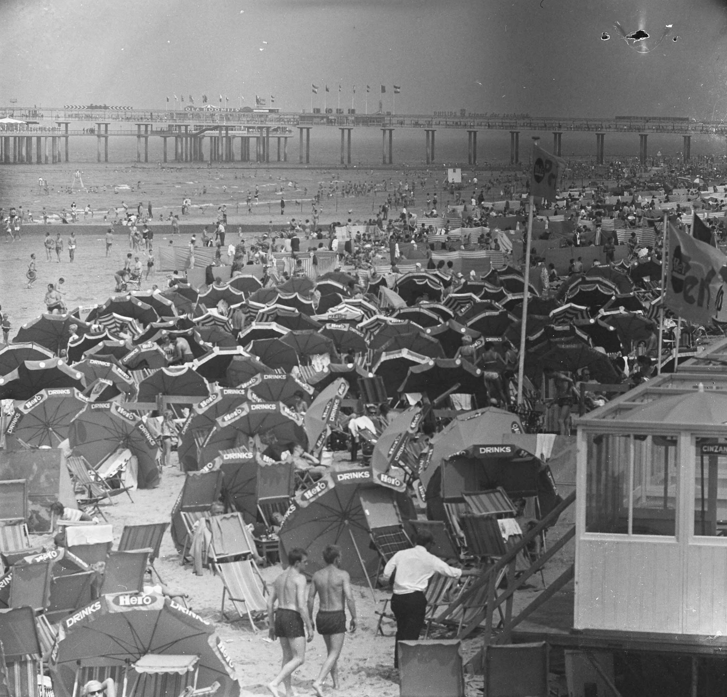 Fotocollectie Anefo — Zomerse dag, onder en tussen de parasols op Scheveningen — Foto: Voets, Jan / Anefo. Licentie: Set B: Rechtenvrij / Publiek Domein. Bron: Nationaal Archief. http://hdl.handle.net/10648/aaf11820-d0b4-102d-bcf8-003048976d84
