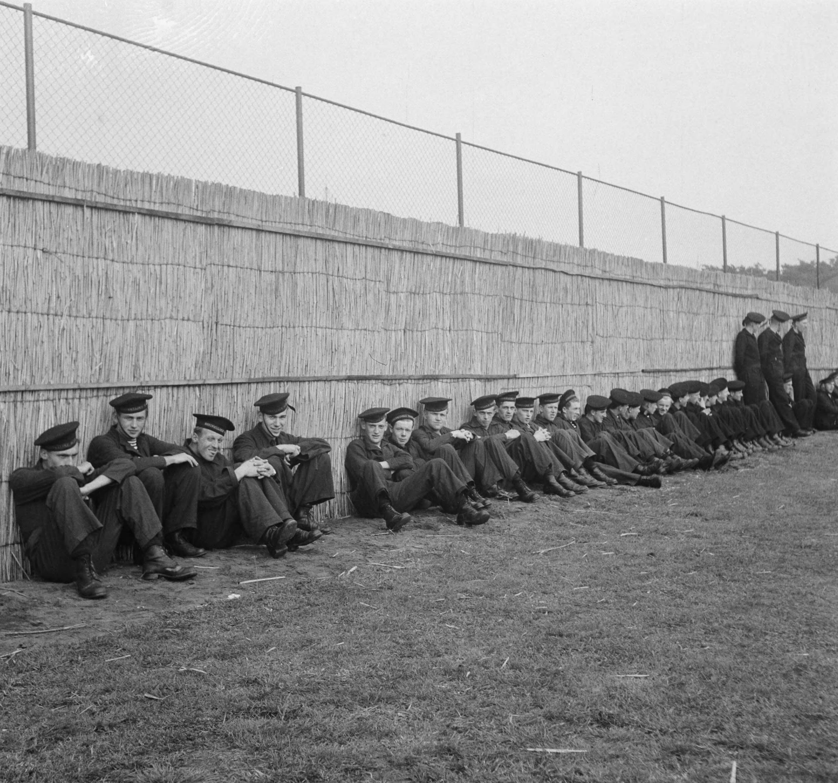 MOK Hilversum 1948 — MOK Hilversum. Matrozen tegen rieten achtergrond — Foto: Steenkamp, B.J.J. (Ben) / Anefo. Licentie: Set B: Rechtenvrij / Publiek Domein. Bron: Nationaal Archief. http://hdl.handle.net/10648/a8bd9d94-d0b4-102d-bcf8-003048976d84
