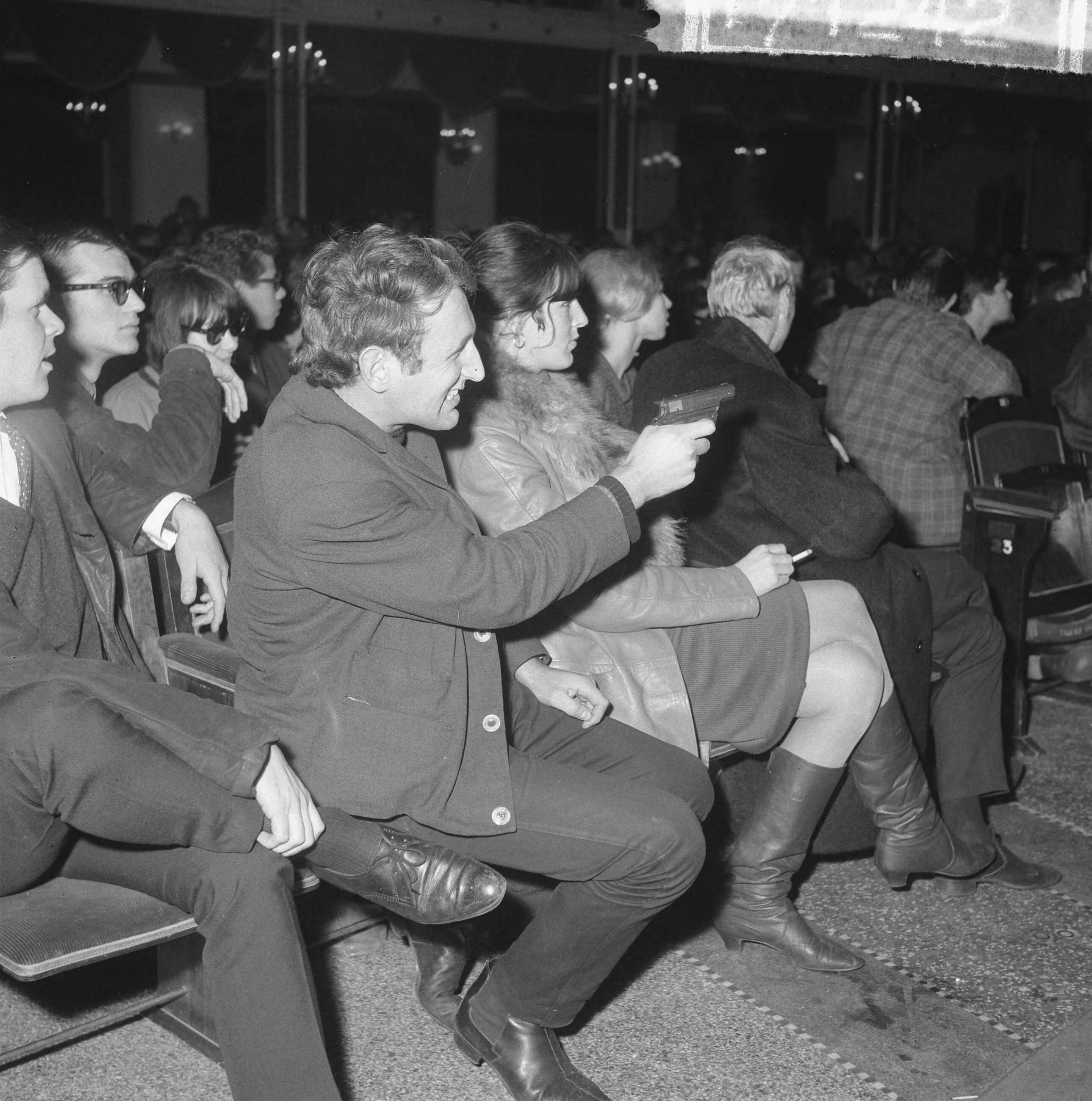 Fotocollectie Anefo — Fluxus-groep gaf Pop-Art-Concert in Kurhaus, een van de bezoekers schoot met een zogenaamd Japans erwtenpistooltje (verboden) — Foto: Gelderen, Hugo van / Anefo. Licentie: Set B: Rechtenvrij / Publiek Domein. Bron: Nationaal Archief. http://hdl.handle.net/10648/aa82b678-d0b4-102d-bcf8-003048976d84