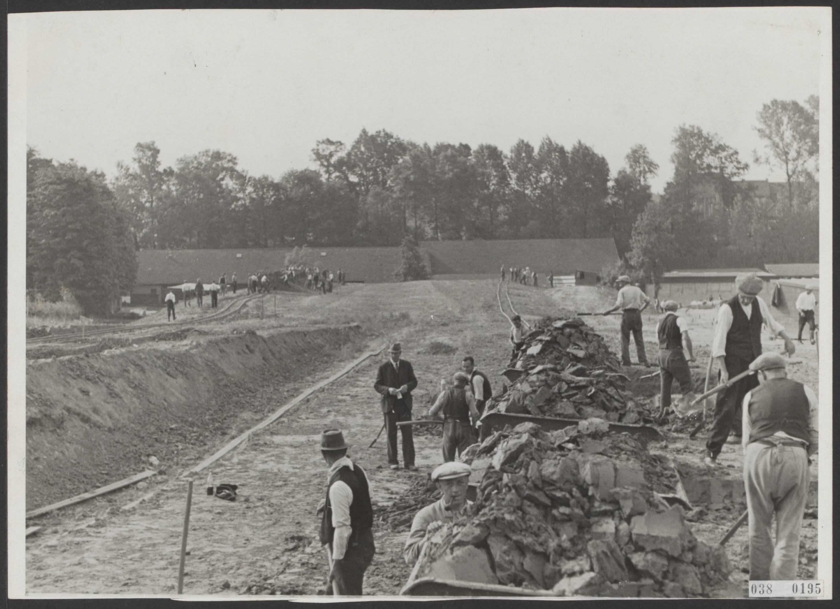 Fotocollectie Elsevier Binnenland — Snelweg Heerlen-Geleen - met aansluiting op Aken - in wording. Alle grond die men hier ziet moet verwerkt worden en ook de huizen in de verte moeten verdwijnen, omdat de weg onder een viaduct door moet (van waaraf de foto werd genomen) — Foto: Onbekend / Publiek Domein of Rechtenvrij. Licentie: Set B: Rechtenvrij / Publiek Domein. Bron: Nationaal Archief. http://hdl.handle.net/10648/adf0ee42-d0b4-102d-bcf8-003048976d84