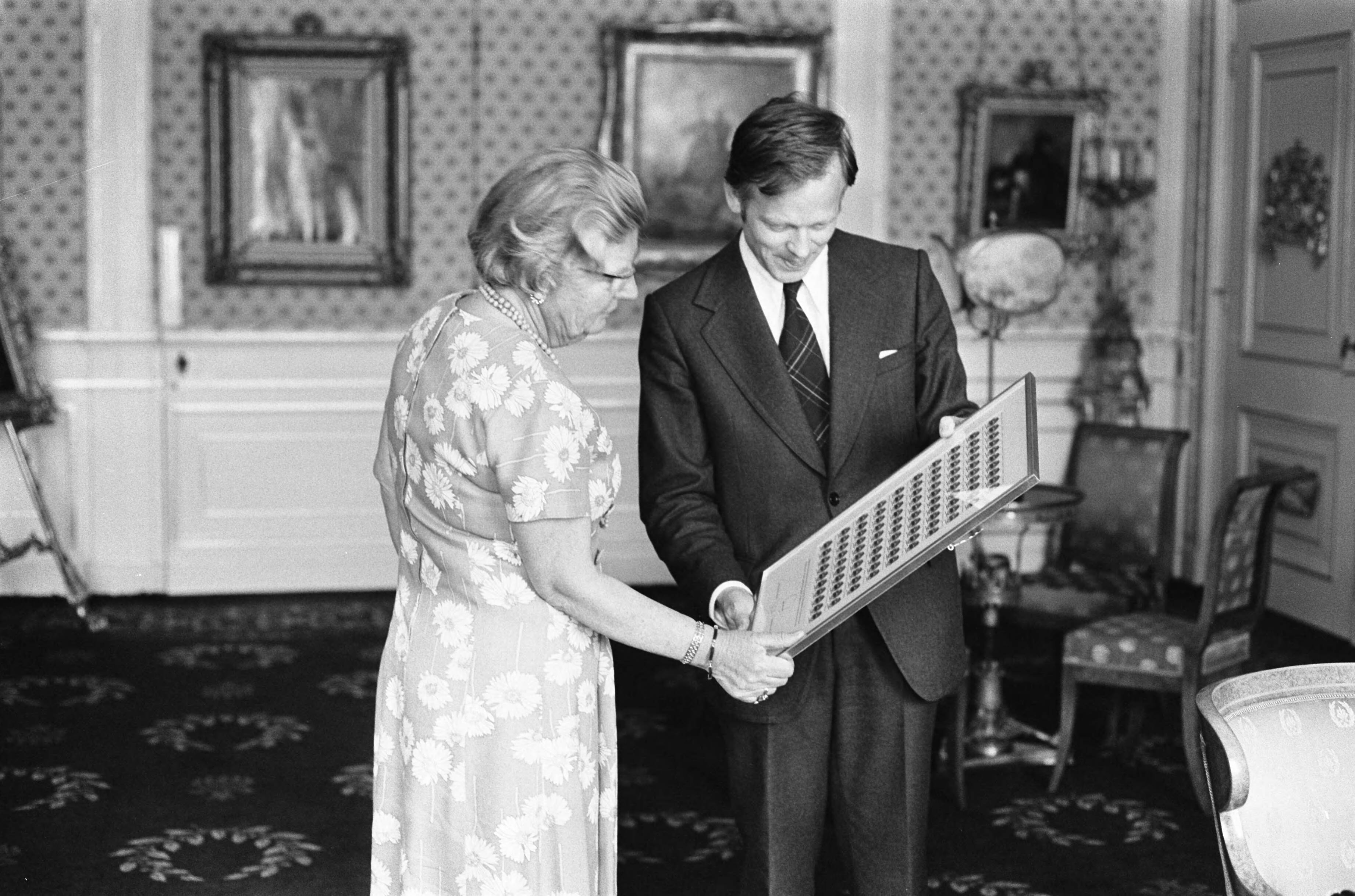 Koningin Juliana ontvangt op Paleis Soestdijk de eerste bevrijdingszegel 1945-1975 [ontwerp van Cas Oorthuys] uit handen van staatssecretaris Michel van Hulten — Baarn|koninginnen |staatssecretarissen |postzegels |herdenkingen|Hulten, Michel van |Juliana, koningin|Utrecht (prov.)|Paleis Soestdijk — Foto: Peters, Hans / Anefo. Licentie: Set B: Rechtenvrij / Publiek Domein. Bron: Nationaal Archief. http://hdl.handle.net/10648/ac6762d6-d0b4-102d-bcf8-003048976d84