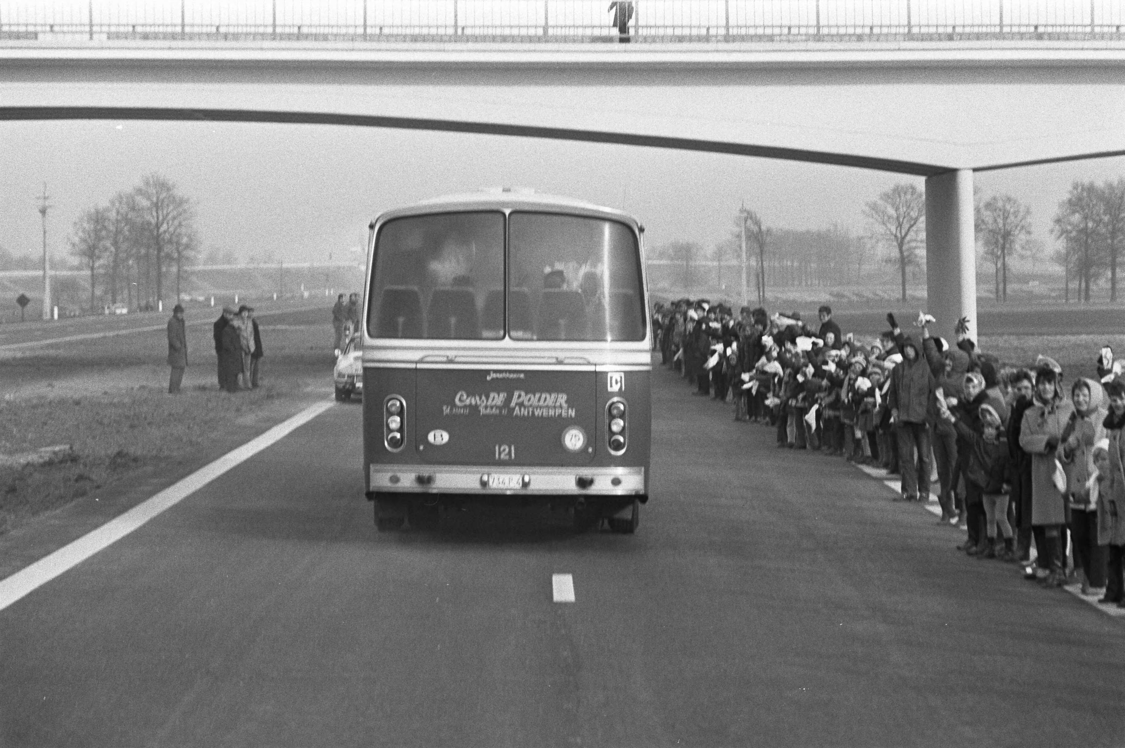 Opening van de E10, de nieuwe snelweg tussen Breda en Antwerpen, door — De bus met daarin koningin Juliana en koning Boudewijn op de nieuwe weg — Foto: Fotograaf Onbekend / Anefo. Licentie: Set B: Rechtenvrij / Publiek Domein. Bron: Nationaal Archief. http://hdl.handle.net/10648/abde6058-d0b4-102d-bcf8-003048976d84