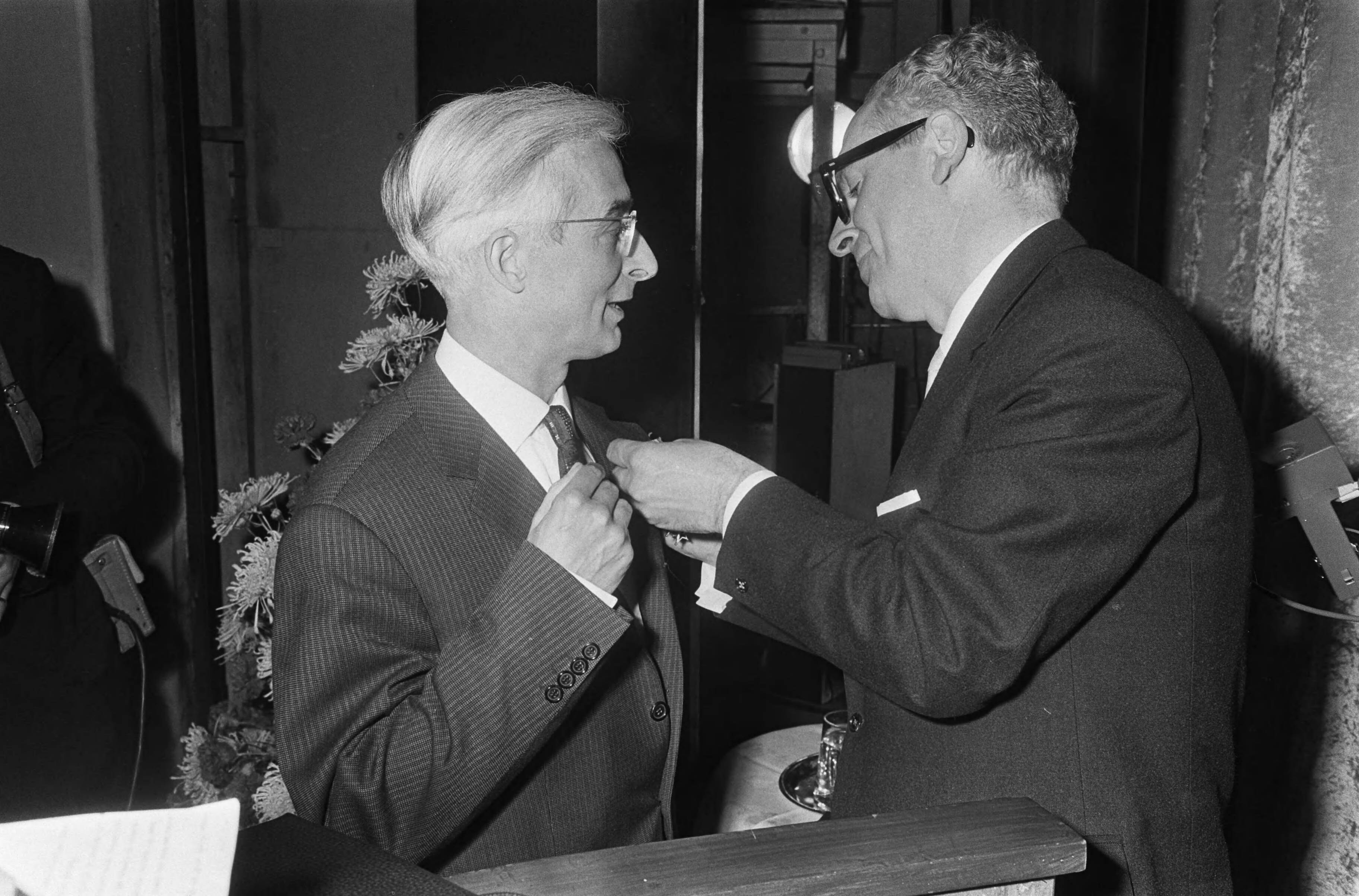 Viering van het veertigjarig bestaan van de Katholieke Radio Omroep (K.R.O.) in theater Gooiland te Hilversum — Minister Vrolijk bij het opspelden van de koninklijke onderscheiding bij mr. W. Wagenaar — Foto: Fotograaf Onbekend / Anefo. Licentie: Set B: Rechtenvrij / Publiek Domein. Bron: Nationaal Archief. http://hdl.handle.net/10648/aacde04e-d0b4-102d-bcf8-003048976d84