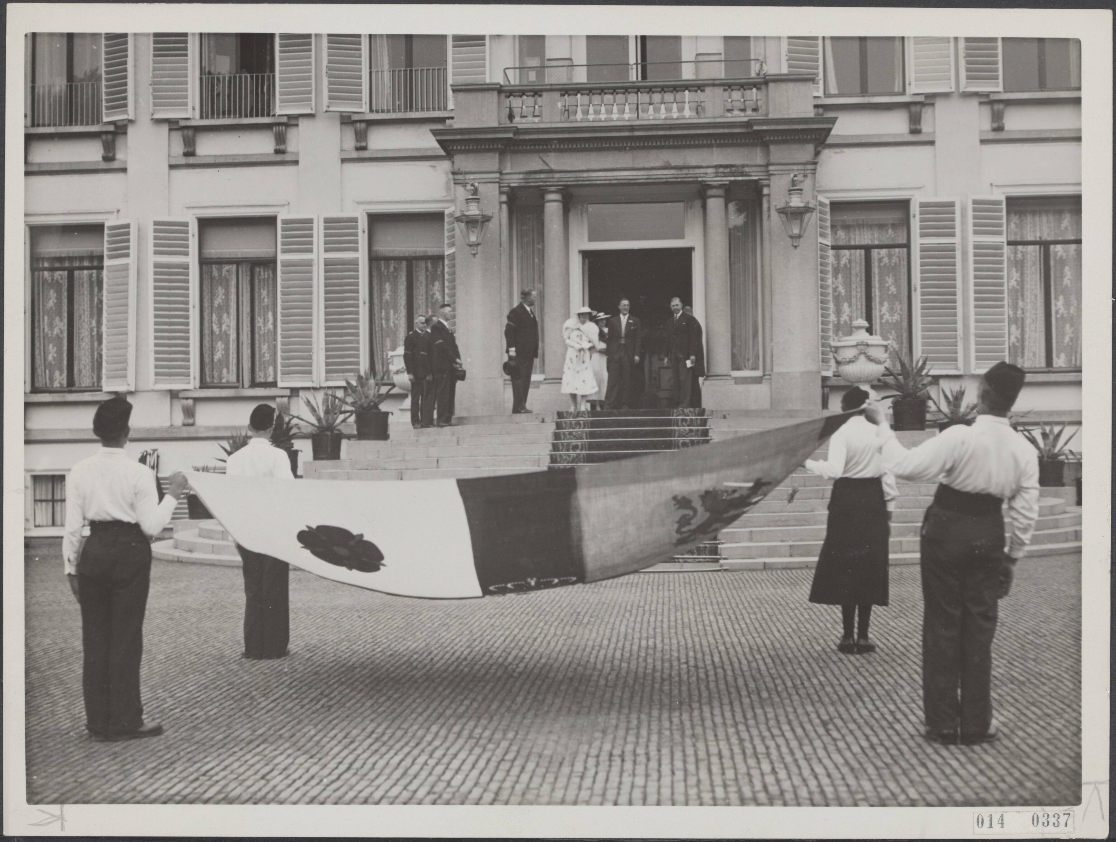 Fotocollectie Elsevier Binnenland — Aanbieding aan prinses Juliana en prins Bernhard van de nieuwe paleis- en autostandaards door de vereniging "De Princevlag" op Paleis Soestdijk. De grote standaard wordt aangeboden. Links de heer Joh. G. Berlot (voorzitter) en rechts jhr. C. Dedel — Foto: N.V. Polygoon. Licentie: Set B: Rechtenvrij / Publiek Domein. Bron: Nationaal Archief. http://hdl.handle.net/10648/adb05242-d0b4-102d-bcf8-003048976d84