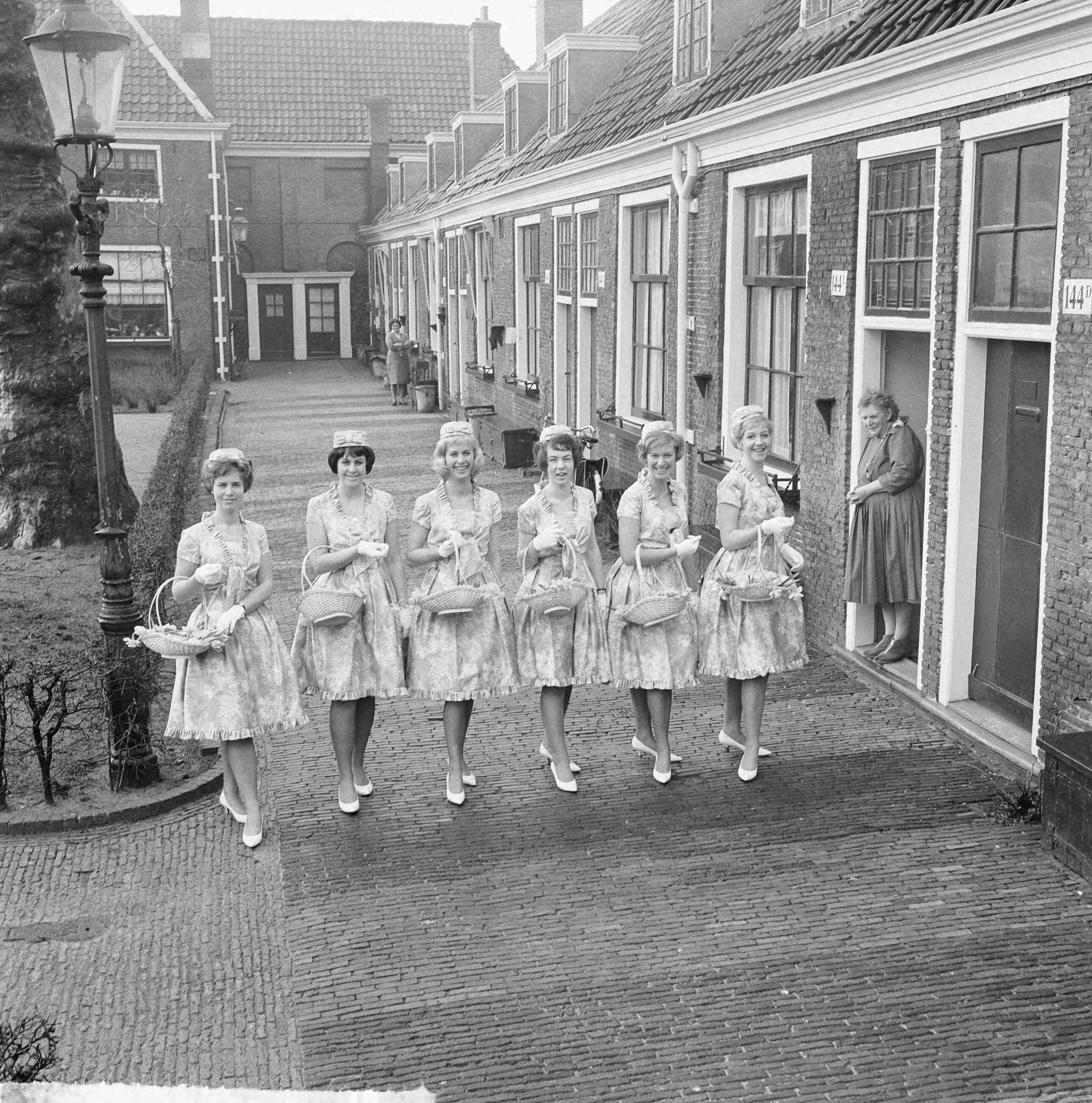 Fotocollectie Anefo — Haarlemse bloemenmeisjes in nieuw pakje, hun nieuwe Boussac katoenen jurkjes. Enkele meisjes op het Proveniershofje te Haarlem — Foto: Nijs, Jac. de / Anefo. Licentie: Set B: Rechtenvrij / Publiek Domein. Bron: Nationaal Archief. http://hdl.handle.net/10648/aa2e6cda-d0b4-102d-bcf8-003048976d84
