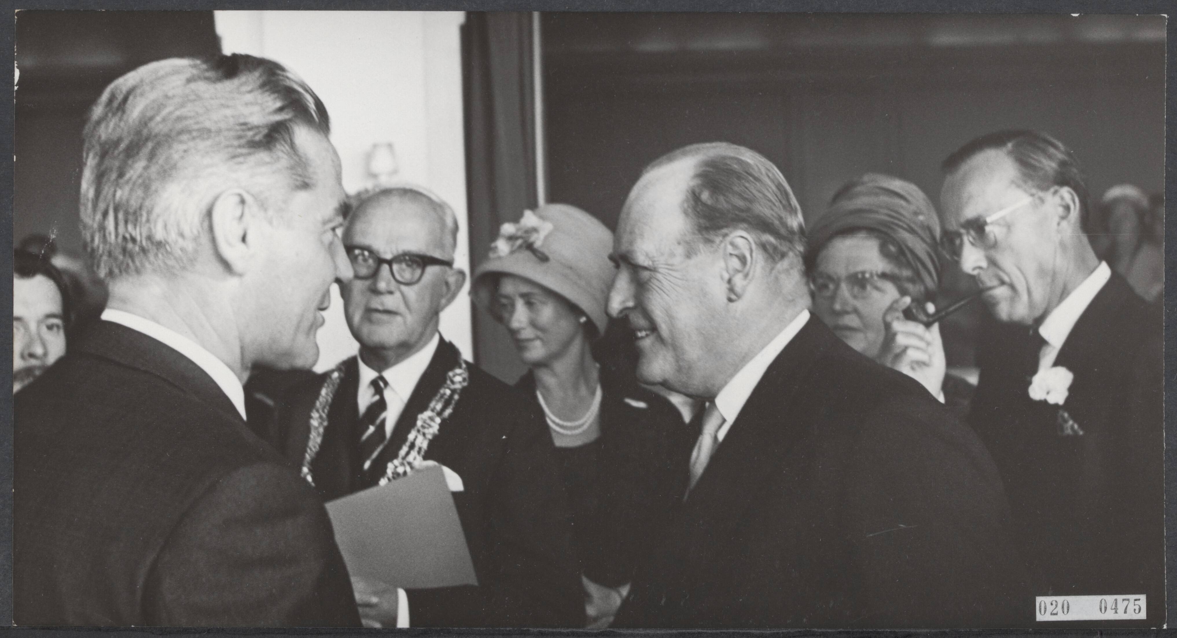 Fotocollectie Elsevier Binnenland — [Staatsbezoek van koning Olav van Noorwegen aan Nederland] Koning Olav van Noorwegen, koningin Juliana en prins Bernhard wonen in het Kurhaus een speciale voorstelling bij van Bert Haanstra´s film alleman. Na de voorstelling onderhield koning Olav zich geruime tijd met Bert Haanstra (links). Recht de koningin en de prins. Rechts van Bert Haanstra de burgemeester van Den Haag, de heer Kolfschoten — Foto: Koch, Eric / Anefo. Licentie: Set B: Rechtenvrij / Publiek Domein. Bron: Nationaal Archief. http://hdl.handle.net/10648/adcaf318-d0b4-102d-bcf8-003048976d84
