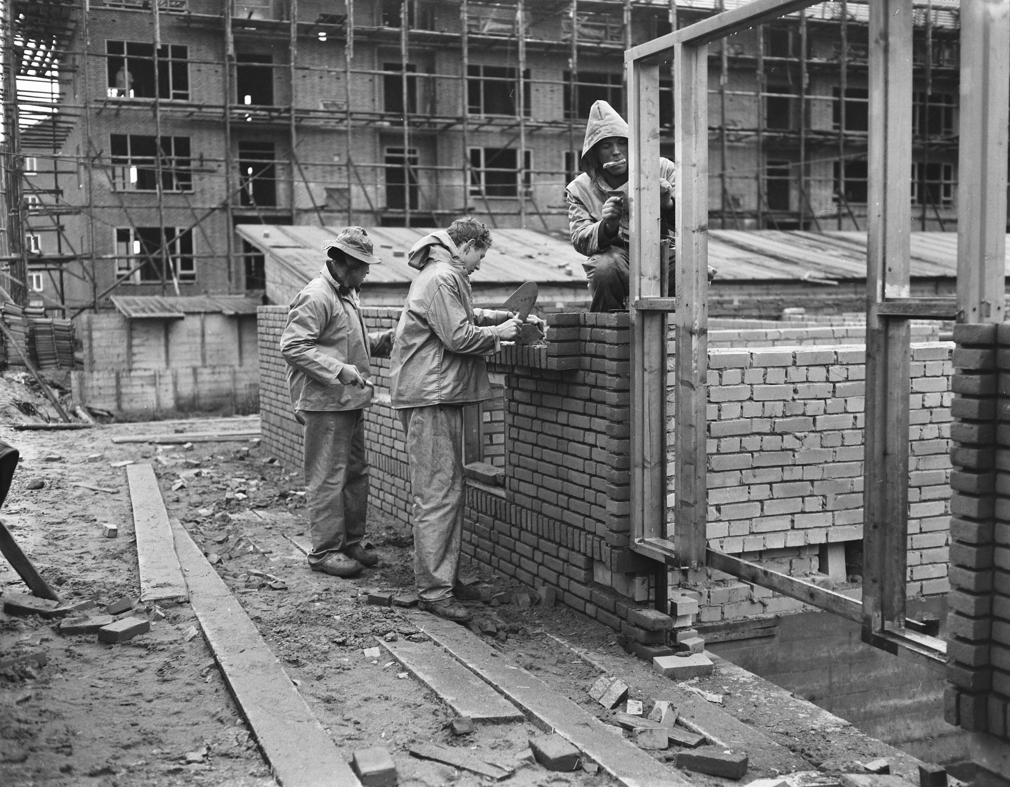 Fotocollectie Anefo — Versnelling woningbouw in de winter (Rijswijk), kleding van de overheid voor de bouwvakarbeiders — Foto: Pot, Harry / Anefo. Licentie: Set B: Rechtenvrij / Publiek Domein. Bron: Nationaal Archief. http://hdl.handle.net/10648/a940af40-d0b4-102d-bcf8-003048976d84