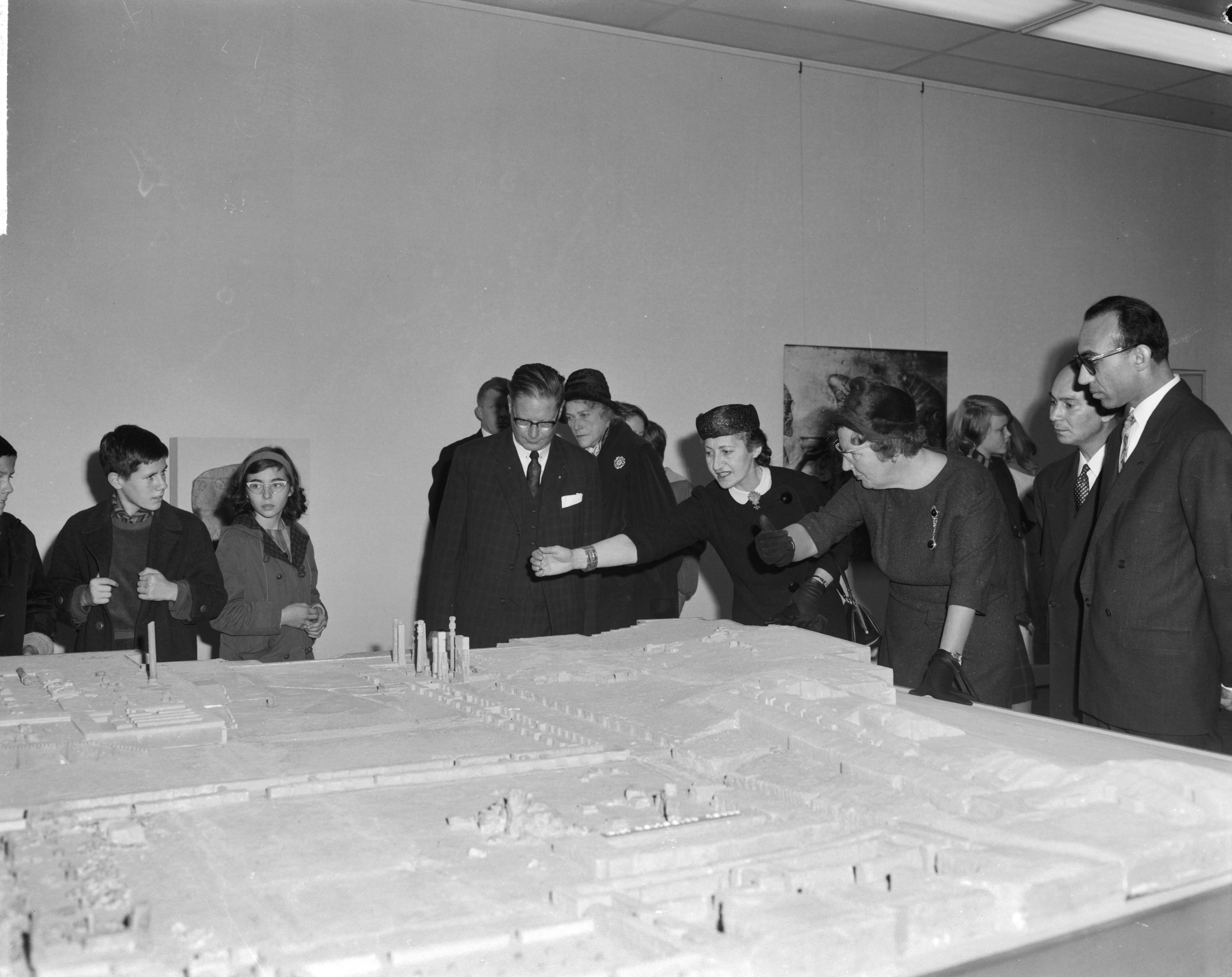 Fotocollectie Anefo — Koningin Juliana brengt een bezoek aan de tentoonstelling 7000 jaar Perzische Kunst te Den Haag, v.l.n.r. Louis Wijsenbeek (directeur), mevrouw Moghun, de koningin en dr. Ferydoun bij een maquette van Persepolis — Foto: Bilsen, Joop van / Anefo. Licentie: Set B: Rechtenvrij / Publiek Domein. Bron: Nationaal Archief. http://hdl.handle.net/10648/aa1dba20-d0b4-102d-bcf8-003048976d84