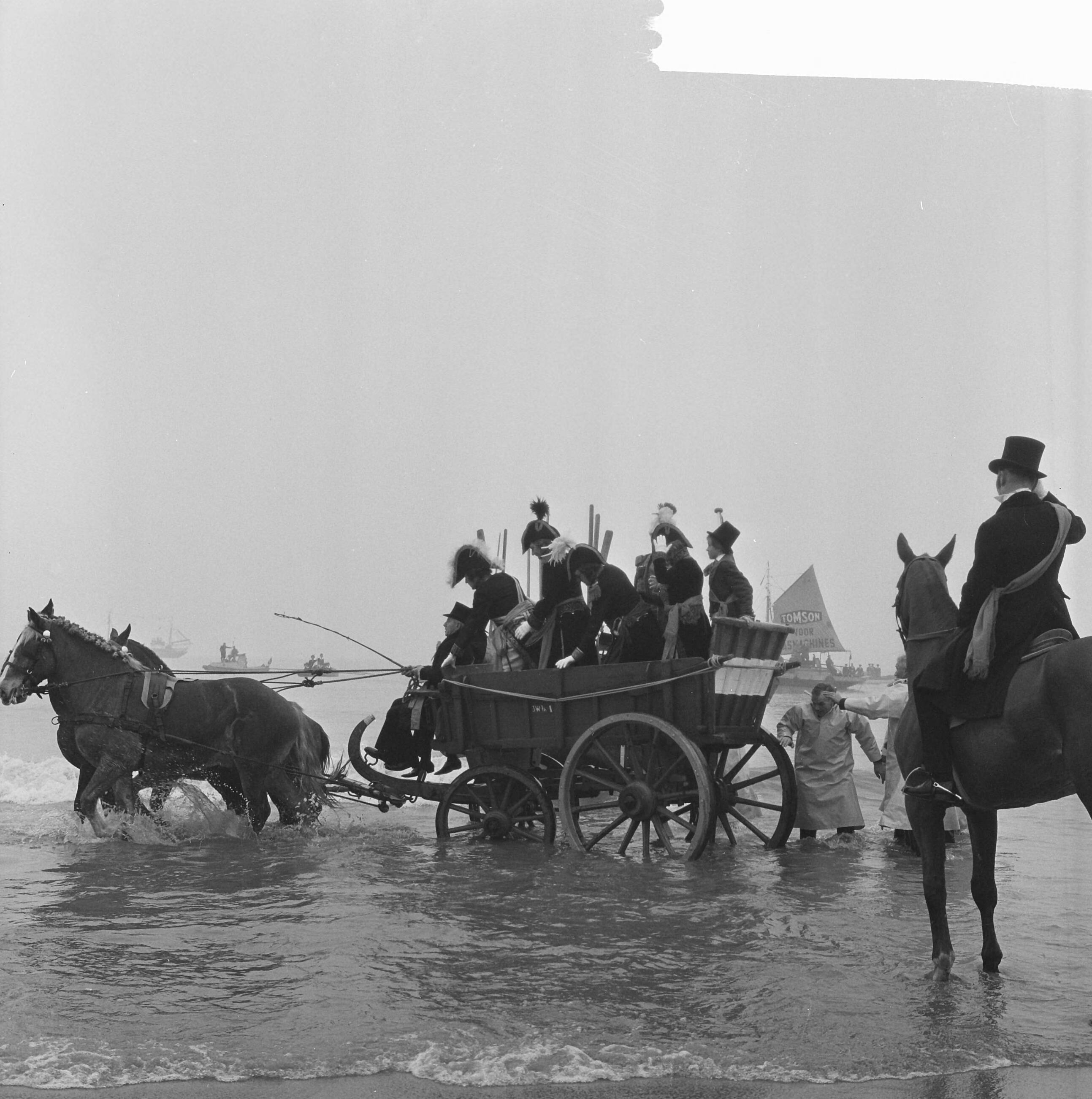 Fotocollectie Anefo — Te Scheveningen is de landing en intocht van prins Willem Frederik in 1813 herdacht. In de branding neemt de prins plaats in een nettenwagen. Op de rug gezien met sjerp het historisch personage Jacob Pronk — Foto: Walta, Winfried / Anefo. Licentie: Set B: Rechtenvrij / Publiek Domein. Bron: Nationaal Archief. http://hdl.handle.net/10648/aa500d0e-d0b4-102d-bcf8-003048976d84
