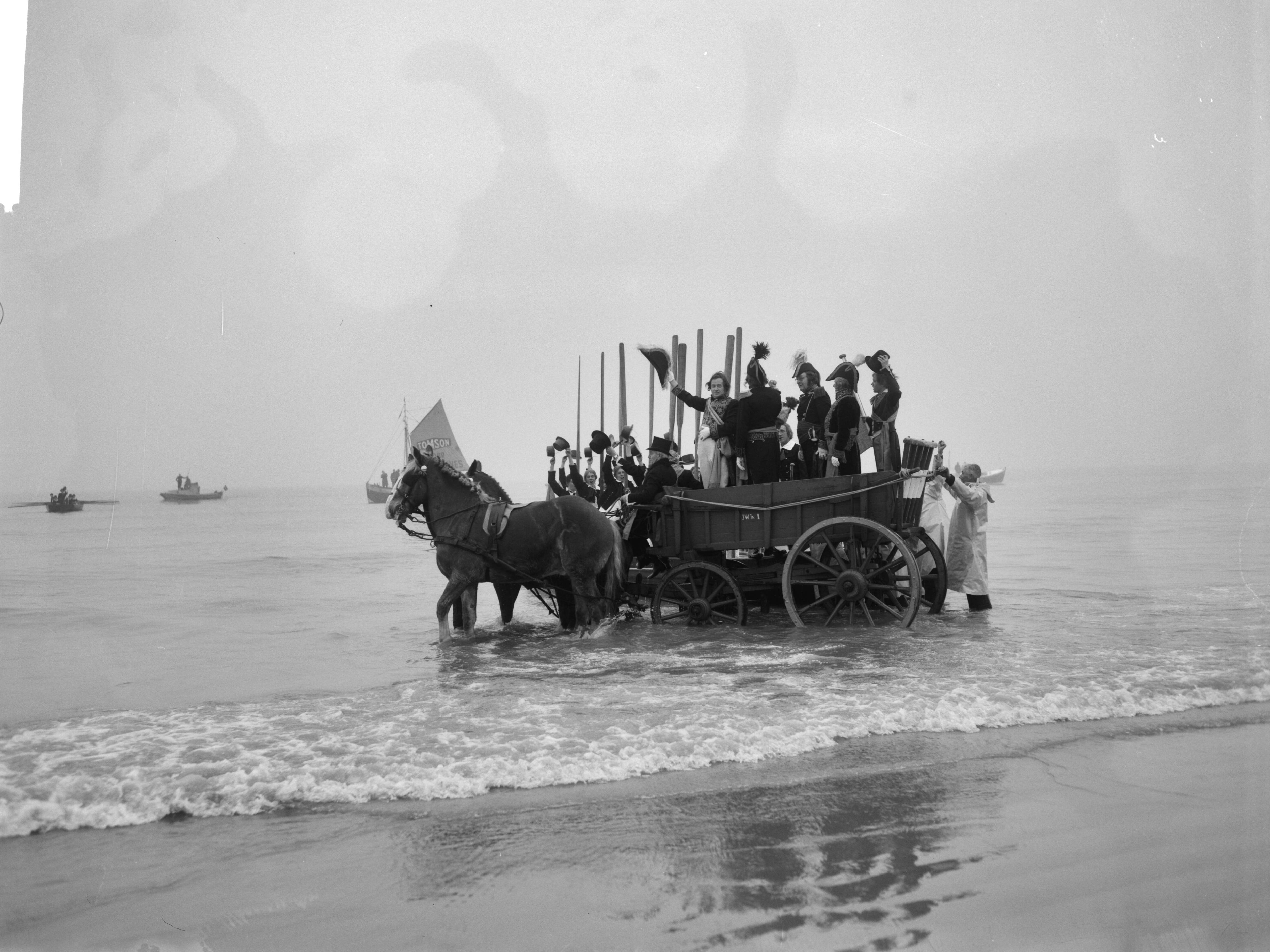 Fotocollectie Anefo — Te Scheveningen is de landing en intocht van prins Willem Frederik in 1813 herdacht. Aankomst van prins Willem Frederik op het strand. In een nettenwagen wordt hij van het strand gereden — Foto: Bilsen, Joop van / Anefo. Licentie: Set B: Rechtenvrij / Publiek Domein. Bron: Nationaal Archief. http://hdl.handle.net/10648/aa5011a0-d0b4-102d-bcf8-003048976d84