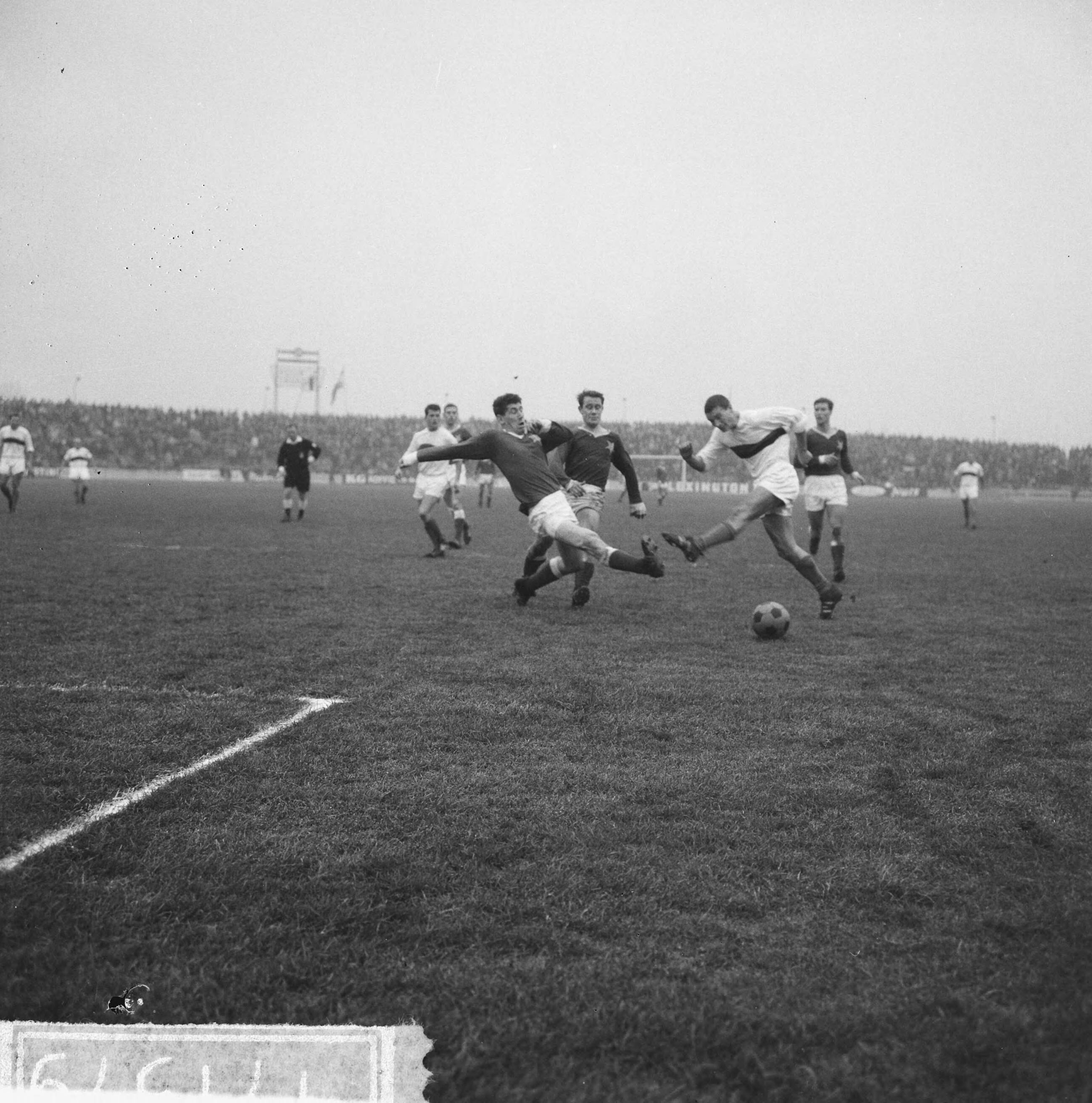 Fotocollectie Anefo — Voetbal. MVV tegen DWS 2-0. Spelmoment, Tijn van Lier (DWS) struikelt op de MVV defensie — Foto: Nijs, Jac. de / Anefo. Licentie: Set B: Rechtenvrij / Publiek Domein. Bron: Nationaal Archief. http://hdl.handle.net/10648/aa84030c-d0b4-102d-bcf8-003048976d84