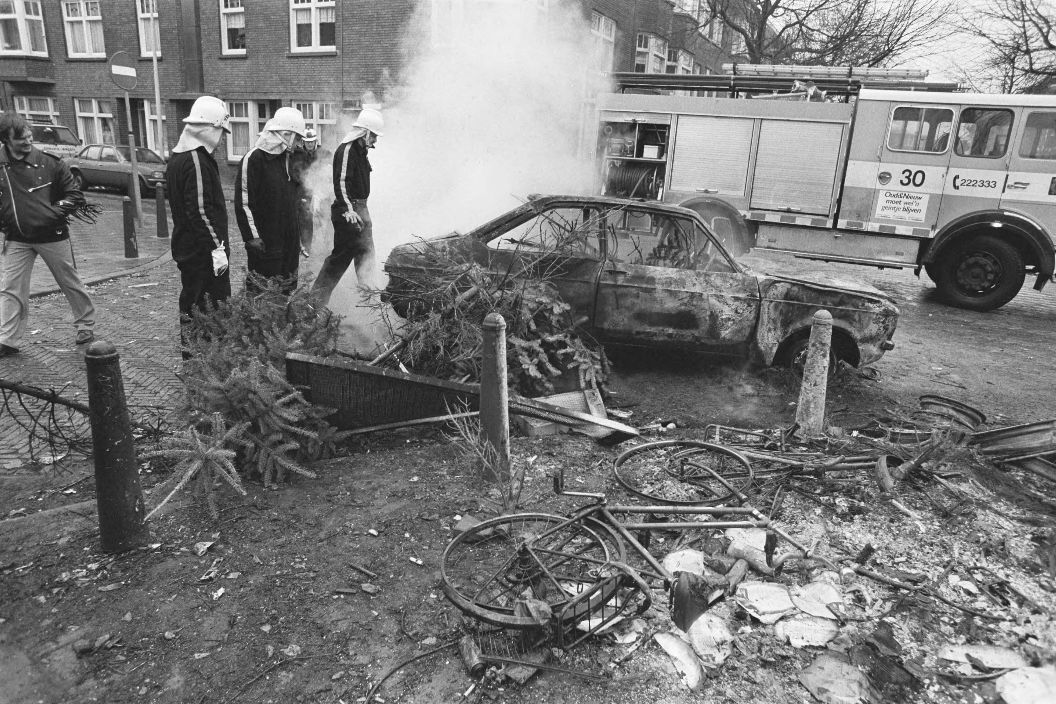 Fotocollectie Anefo — Brandweer bij uitgebrand autowrak in Den Haag na ouderjaarsnacht — Foto: Bogaerts, Rob / Anefo. Licentie: Set B: Rechtenvrij / Publiek Domein. Bron: Nationaal Archief. http://hdl.handle.net/10648/ad5b1f20-d0b4-102d-bcf8-003048976d84