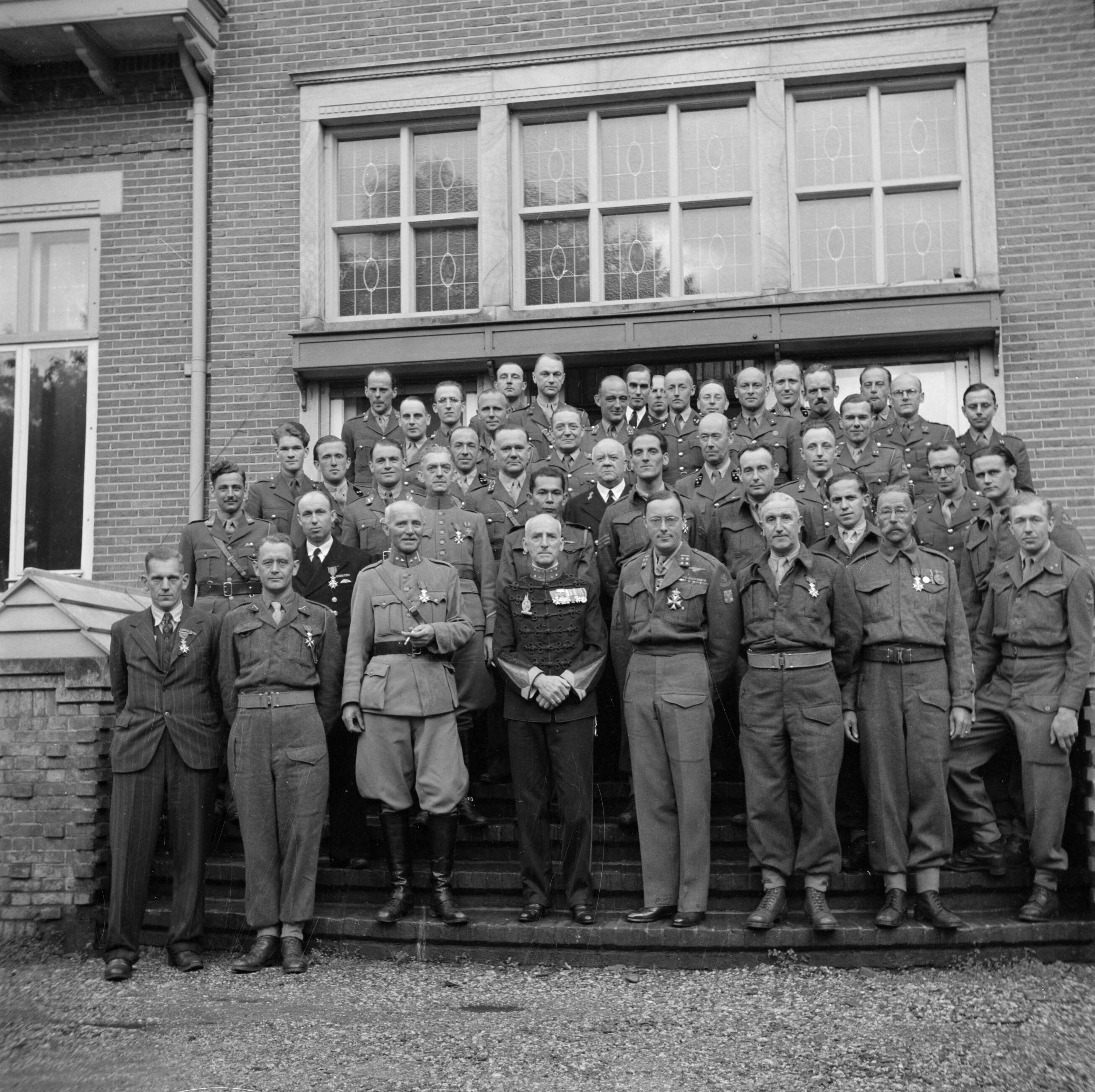 Uitreiking van de Militaire Willems-Orde en andere onderscheidingen door koningin Wilhelmina in aanwezigheid van de overige leden van de koninklijke familie op de vliegbasis Soesterberg — Groepsportret van de gedecoreerden met vooraan vierde van rechts prins Bernhard en derde van links kolonel W. F. Hennink, commandant van de Grebbeberglinie in mei 1940 — Foto: Poll, Willem van de. Licentie: Set B: Rechtenvrij / Publiek Domein. Bron: Nationaal Archief. http://hdl.handle.net/10648/aee8ed2c-d0b4-102d-bcf8-003048976d84