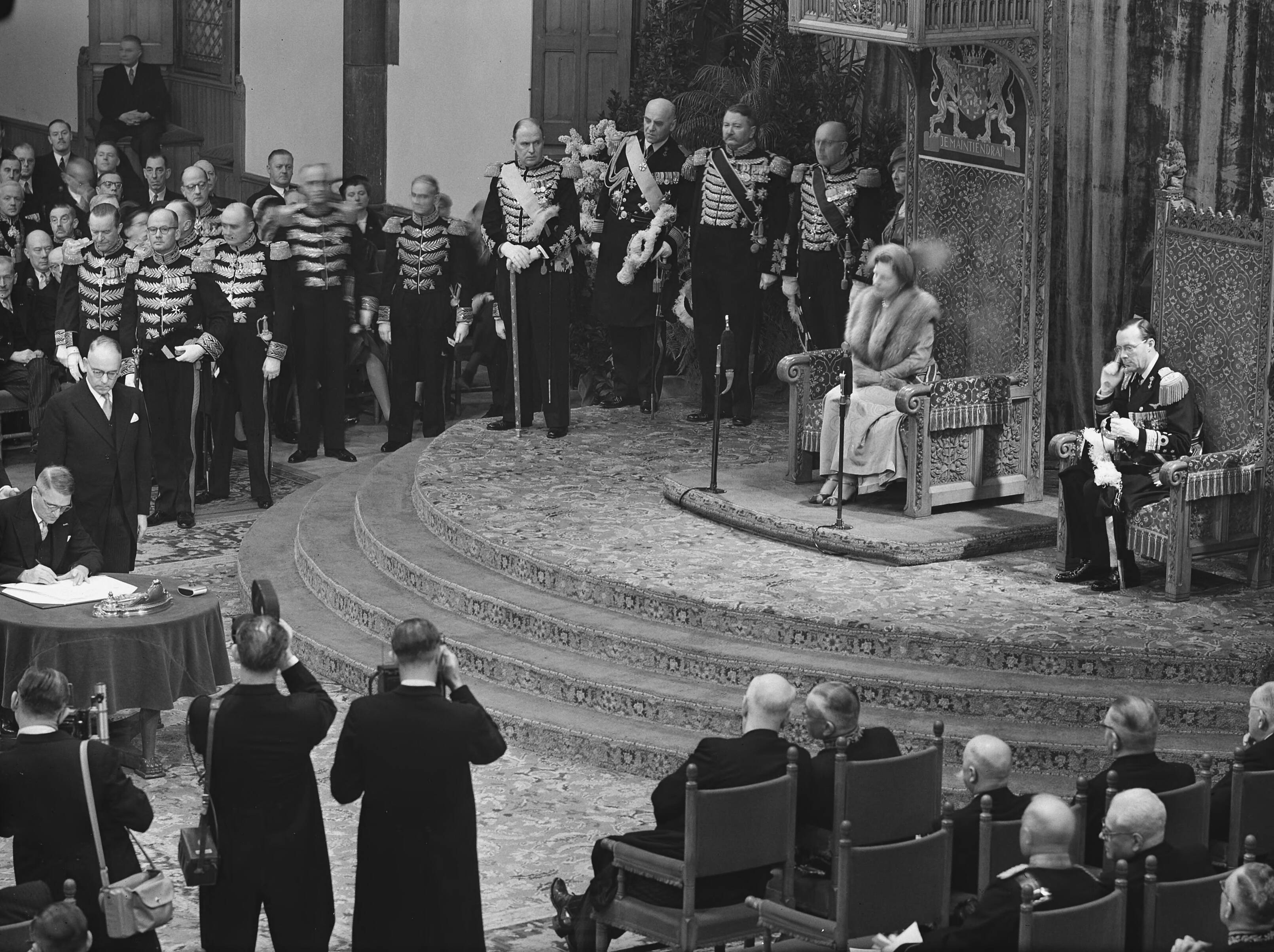 Koningin Juliana ondertekent in een plechtige bijeenkomst in de Ridderzaal in Den Haag de Acte van Bevestiging van het Statuut voor het Koninkrijk — Ondertekening van de Acte van Bevestiging van het Statuut van het Koninkrijk in de Ridderzaal te Den Haag. Toespraak van koningin Juliana — Foto: Bilsen, Joop van / Anefo. Licentie: Set B: Rechtenvrij / Publiek Domein. Bron: Nationaal Archief. http://hdl.handle.net/10648/a92e2a0a-d0b4-102d-bcf8-003048976d84