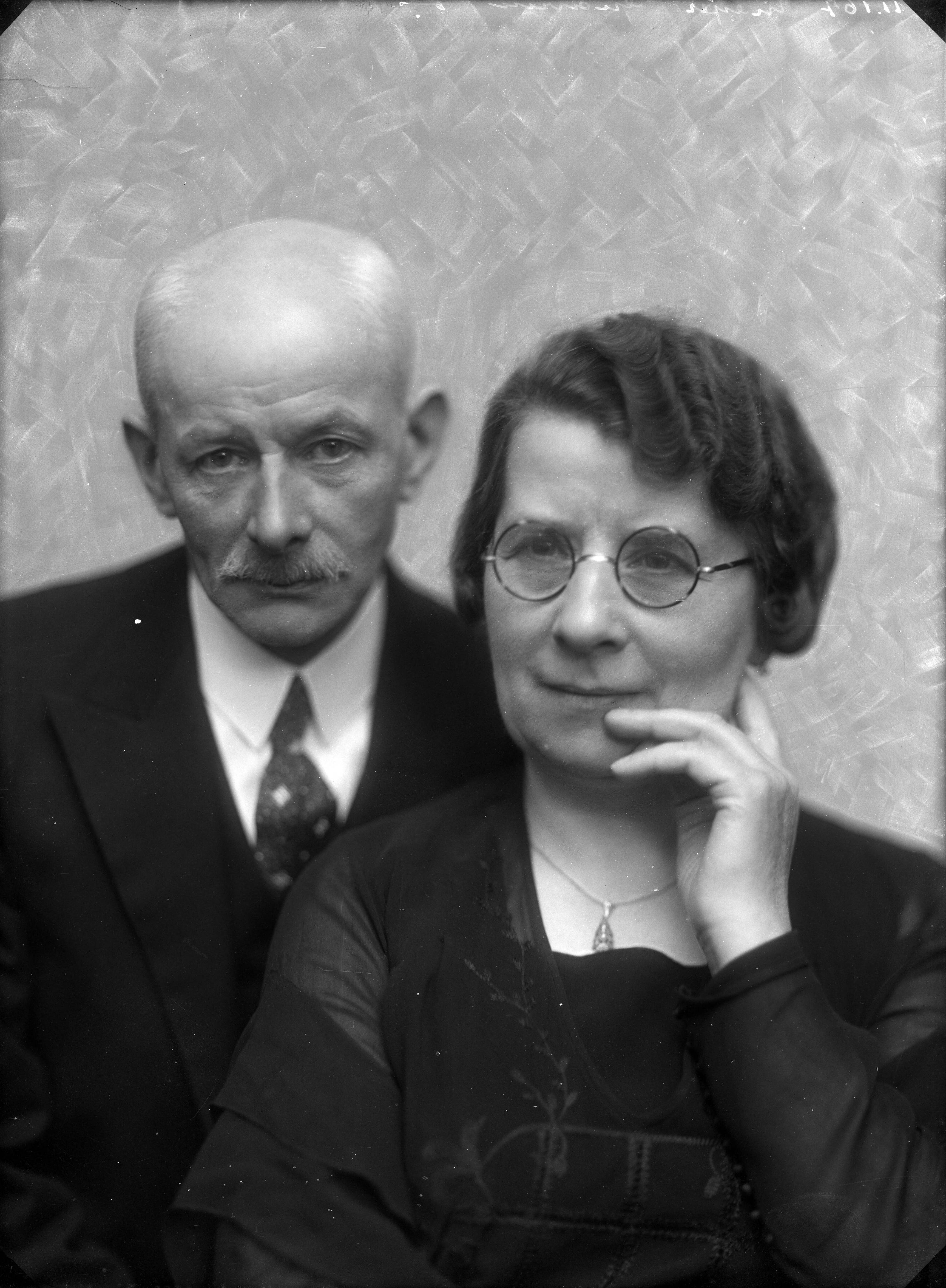 Portretten — Studio-opnames. Portret van een echtpaar op leeftijd. De vrouw met een rond brilletje. Haarlem, Nederland. 1918-1930.11.167 Meijer — Foto: Berg, Th.C.J. van den / Spaarnestad Photo (05887). Licentie: Set B: Rechtenvrij / Publiek Domein. Bron: Nationaal Archief. http://hdl.handle.net/10648/35429da7-c7fc-a382-e063-6df0900a6686