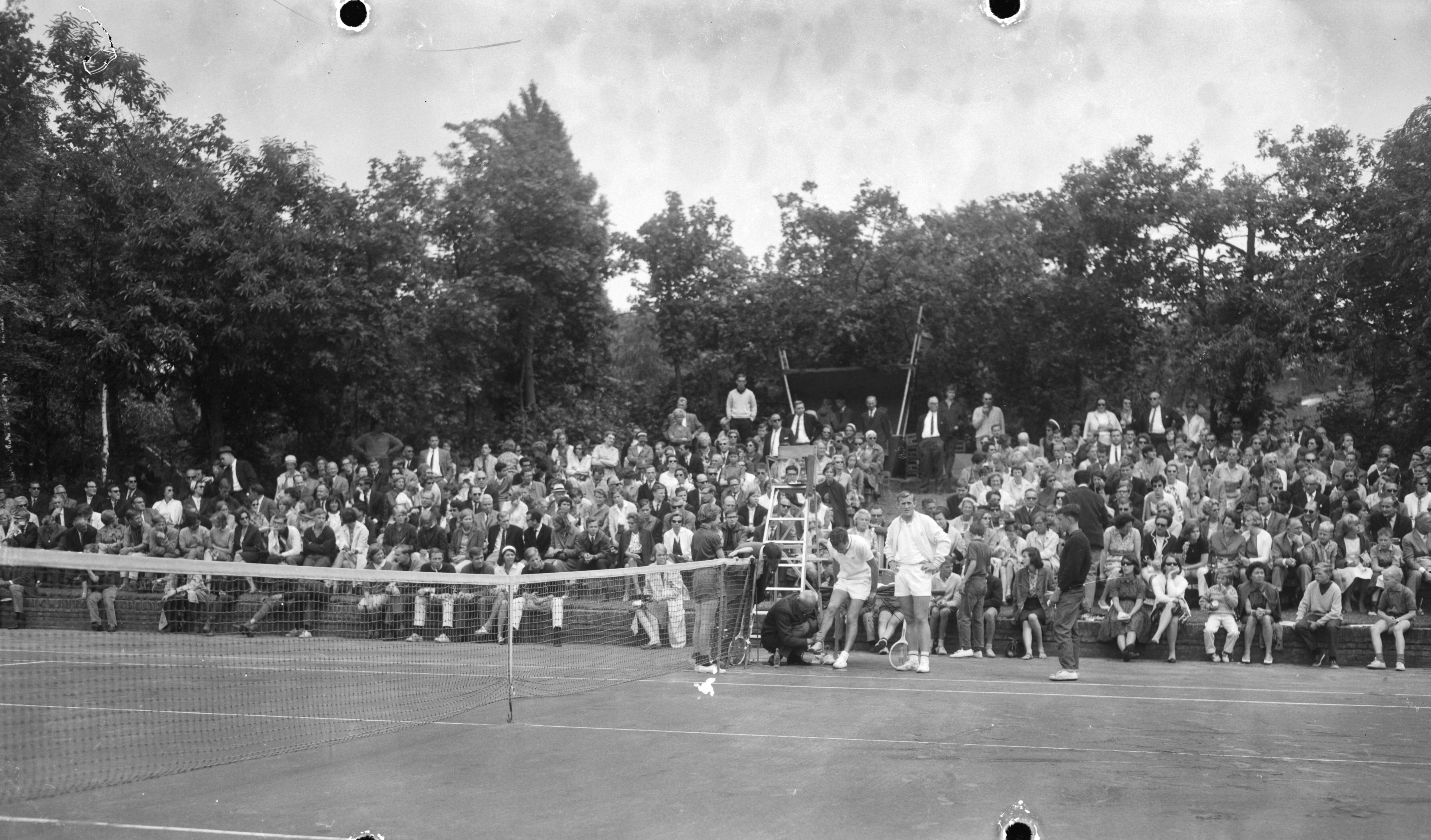 Fotocollectie Anefo — Internationale open tenniskampioenschappen op het Melkhuisje te Hilversum, Tom Okker blesseerde zich aan zijn enkel in zijn partij tegen Tony Roche — Foto: Bilsen, Joop van / Anefo. Licentie: Set B: Rechtenvrij / Publiek Domein. Bron: Nationaal Archief. http://hdl.handle.net/10648/aab5ae20-d0b4-102d-bcf8-003048976d84