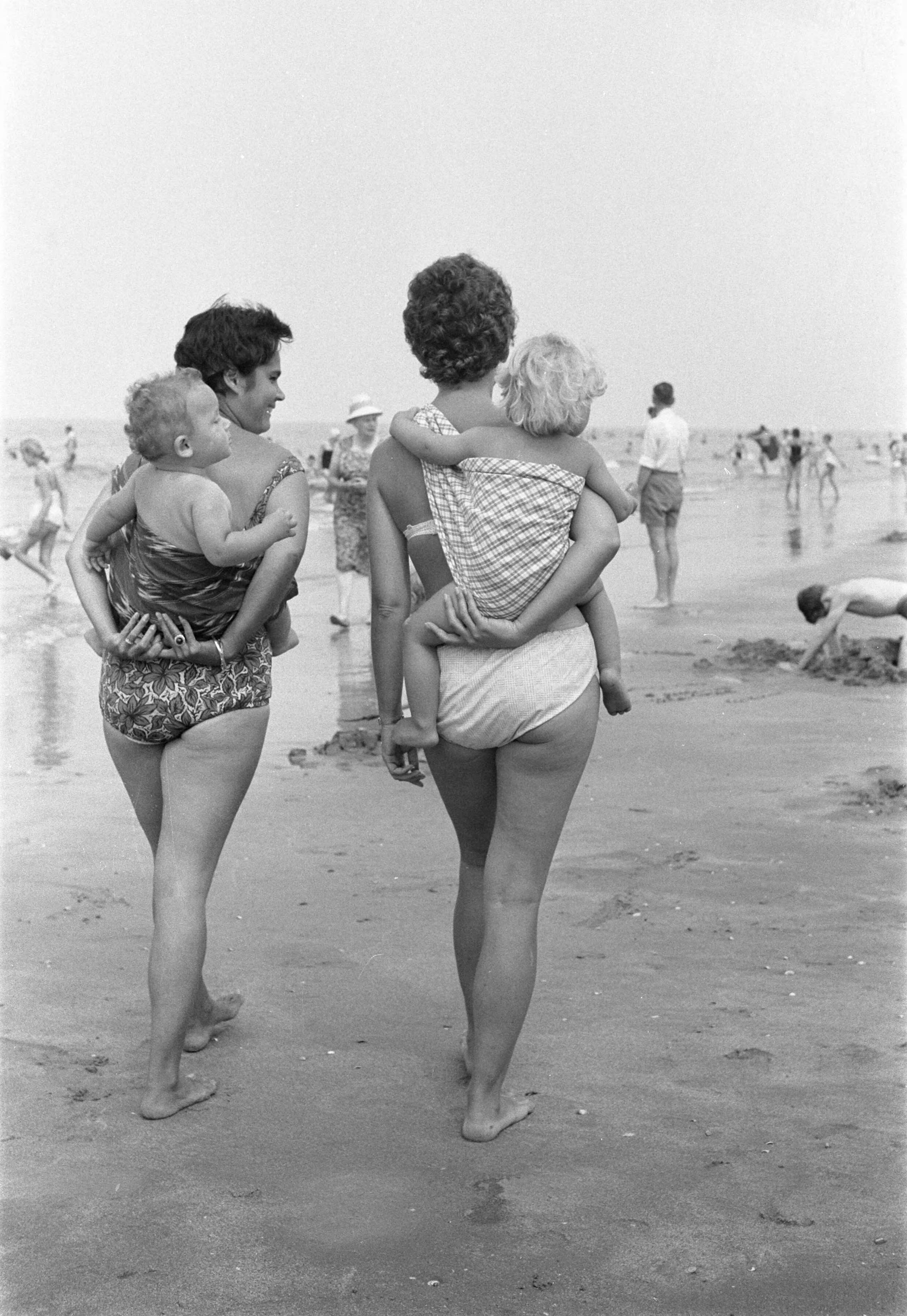 Fotocollectie Anefo — Zandvoort. "Oosterse mode", kinderen in "slendang" op de rug van dames Pot — Foto: Pot, Harry / Anefo. Licentie: Set B: Rechtenvrij / Publiek Domein. Bron: Nationaal Archief. http://hdl.handle.net/10648/a9de34d6-d0b4-102d-bcf8-003048976d84