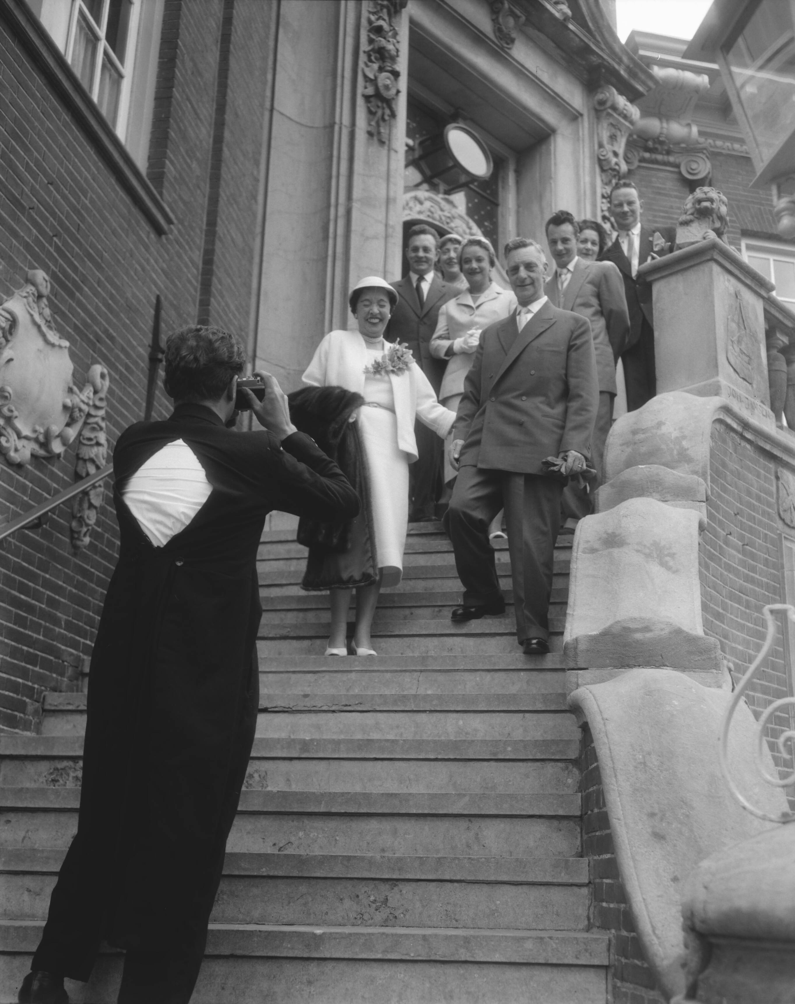 Fotocollectie Anefo — Zandvoortse fotograaf, die uit zijn jasje barst, bij het maken van bruidsfoto's bij het Raadhuis van Zandvoort — Foto: Pot, Harry / Anefo. Licentie: Set B: Rechtenvrij / Publiek Domein. Bron: Nationaal Archief. http://hdl.handle.net/10648/a97c93f2-d0b4-102d-bcf8-003048976d84
