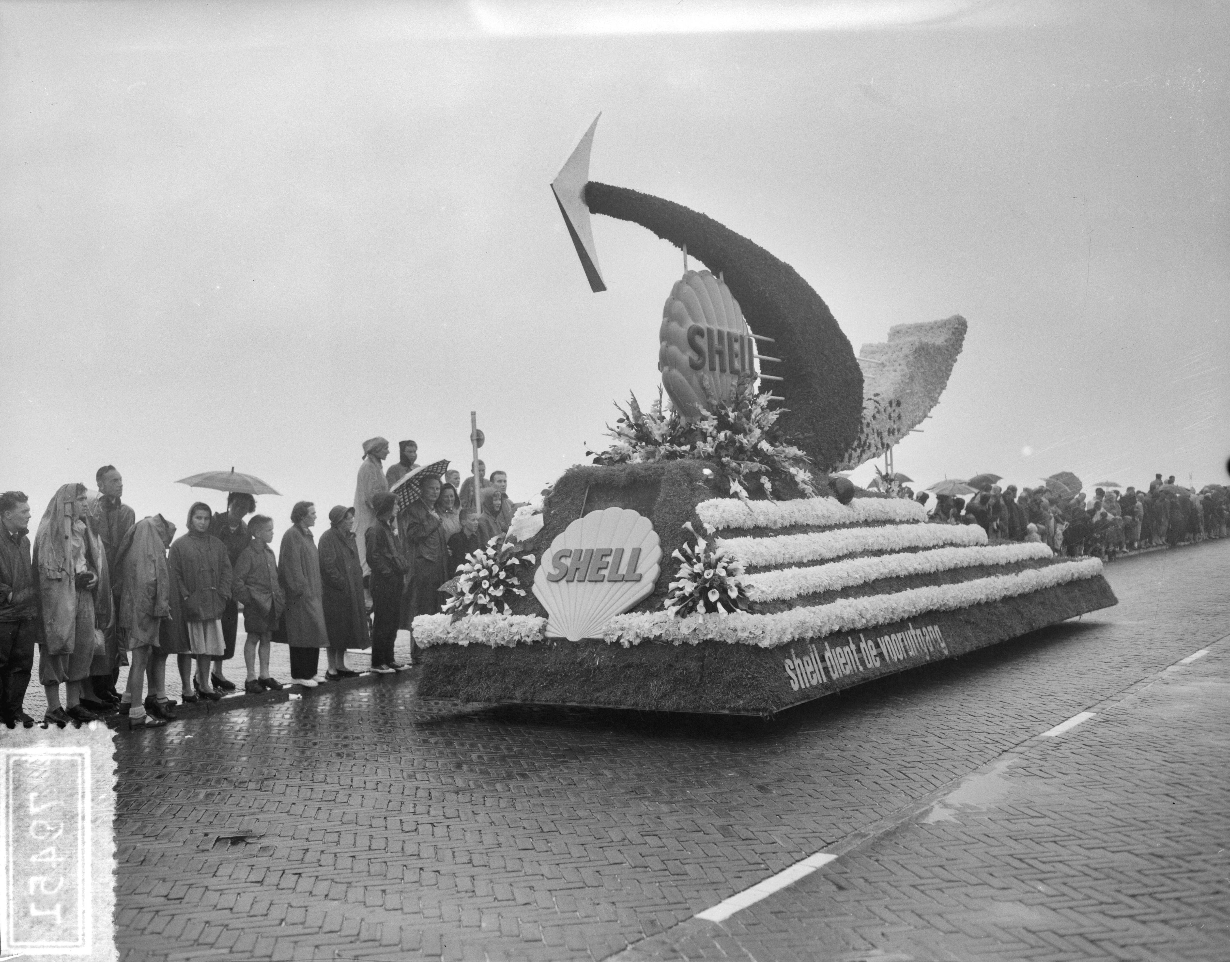Fotocollectie Anefo — Bloemencorso op de boulevard van Scheveningen. Praalwagen van Shell — Foto: Bilsen, Joop van / Anefo. Licentie: Set B: Rechtenvrij / Publiek Domein. Bron: Nationaal Archief. http://hdl.handle.net/10648/a94d4750-d0b4-102d-bcf8-003048976d84