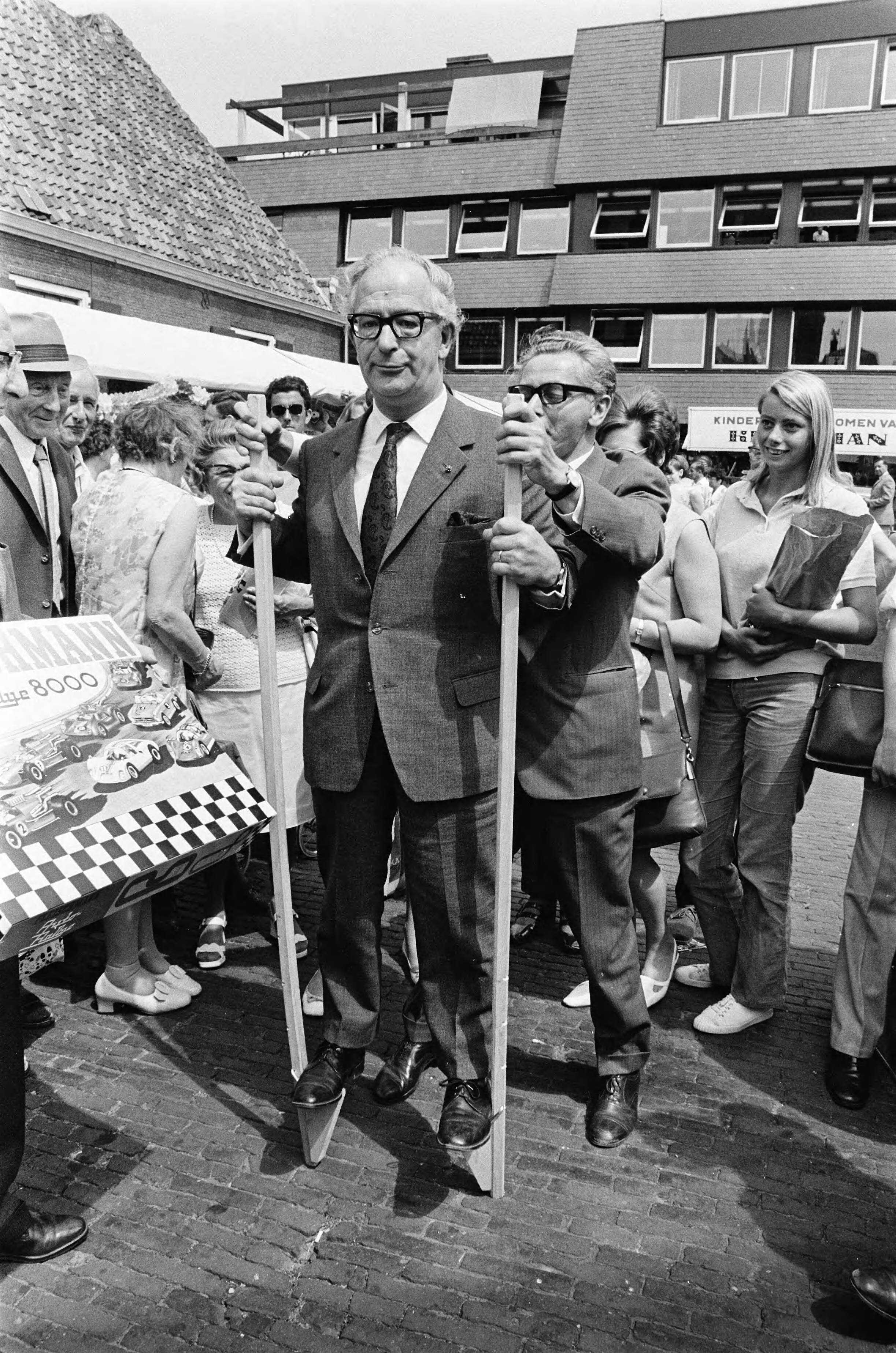Fotocollectie Anefo — Speelmarkt van Speelweek 70 in Alkmaar geopend door waarnemend burgemeester G. H. A. de Zeeuw ; waarnemend burgemeester G. H. A. de Zeeuw op stelten/ — Foto: Evers, Joost / Anefo. Licentie: Set B: Rechtenvrij / Publiek Domein. Bron: Nationaal Archief. http://hdl.handle.net/10648/ab9a1010-d0b4-102d-bcf8-003048976d84