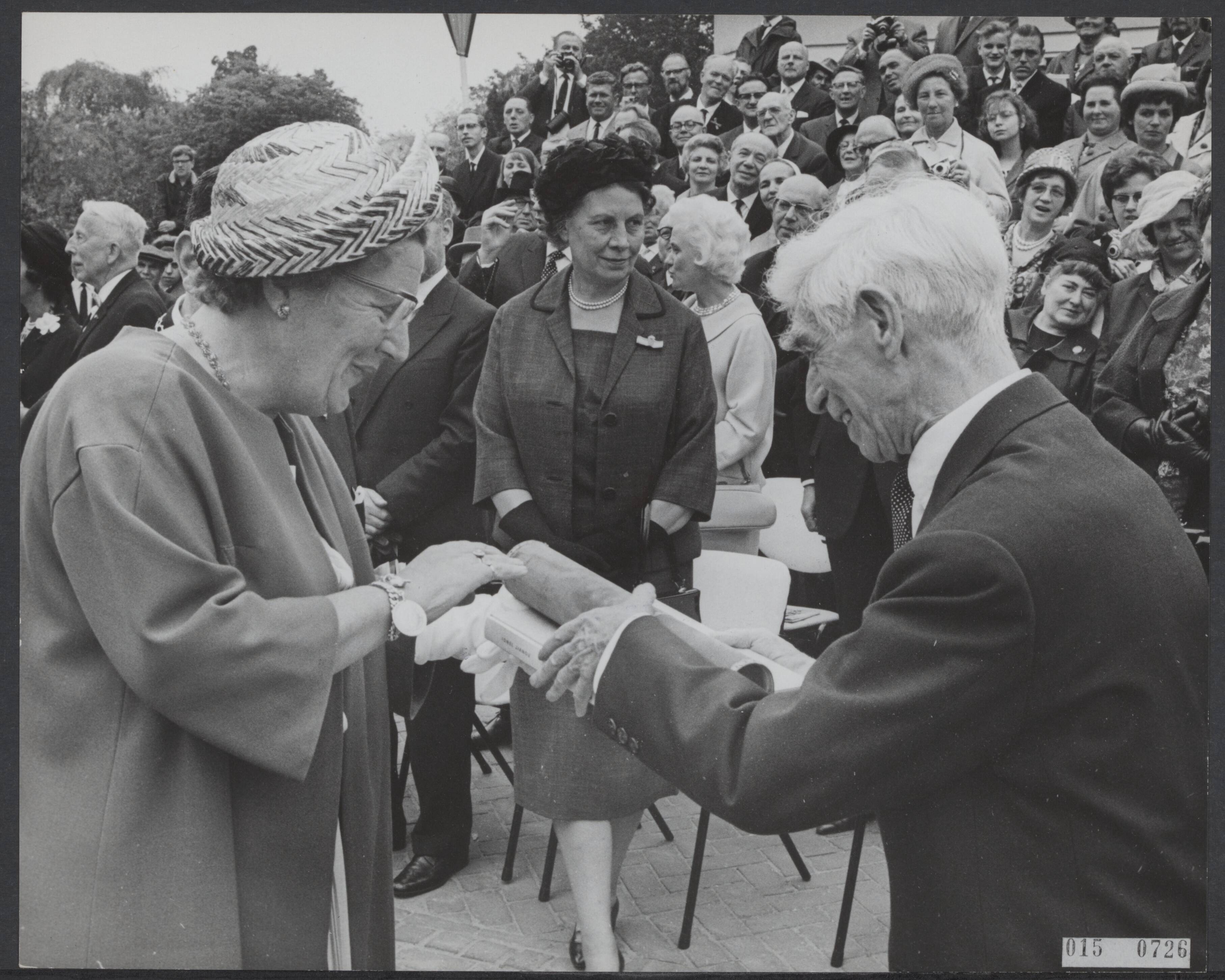 Fotocollectie Elsevier Binnenland — Koningin Juliana heeft in Zundert het Van Gogh monument onthuld. Geheel onverwacht overhandigde de maker van het monument, beeldhouwer Osip Zadkine, de koningin een pakje. Dit bleek een door hem vervaardigde gravure te bevatten die hij speciaal voor koningin had vervaardigd als een persoonlijk geschenk — Foto: Pot, Harry / Anefo. Licentie: Set B: Rechtenvrij / Publiek Domein. Bron: Nationaal Archief. http://hdl.handle.net/10648/adb5f56c-d0b4-102d-bcf8-003048976d84