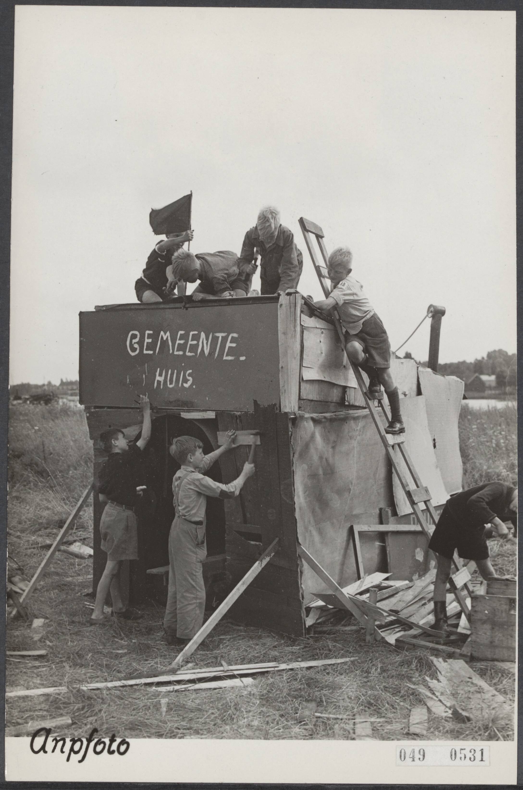 Fotocollectie Elsevier Binnenland — Aan 120 jongens tussen 9 en 13 jaar zijn paspoorten uitgereikt die toegang geven tot het braak liggend terrein aan het eind van de Zaandamse Zuiddijk. Met vereende krachten werd eerst het gemeentehuis gebouwd — Foto: ANP / RVD of rechtenvrij. Licentie: Set B: Rechtenvrij / Publiek Domein. Bron: Nationaal Archief. http://hdl.handle.net/10648/ae01e45e-d0b4-102d-bcf8-003048976d84