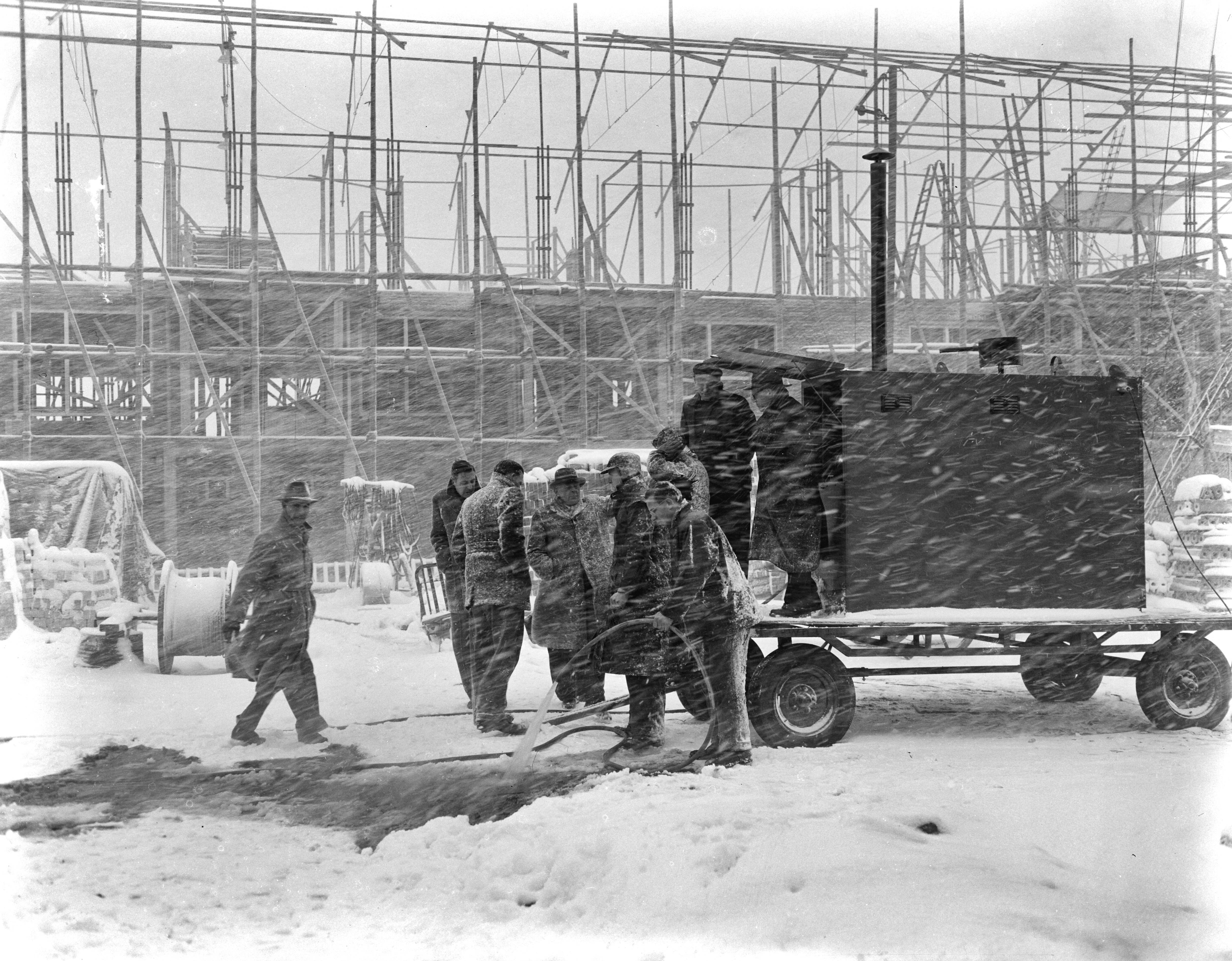 Fotocollectie Anefo — Warm water gieten voor sneeuwvrij maken op bouwplaats te Den Haag — Foto: Pot, Harry / Anefo. Licentie: Set B: Rechtenvrij / Publiek Domein. Bron: Nationaal Archief. http://hdl.handle.net/10648/a9415e90-d0b4-102d-bcf8-003048976d84