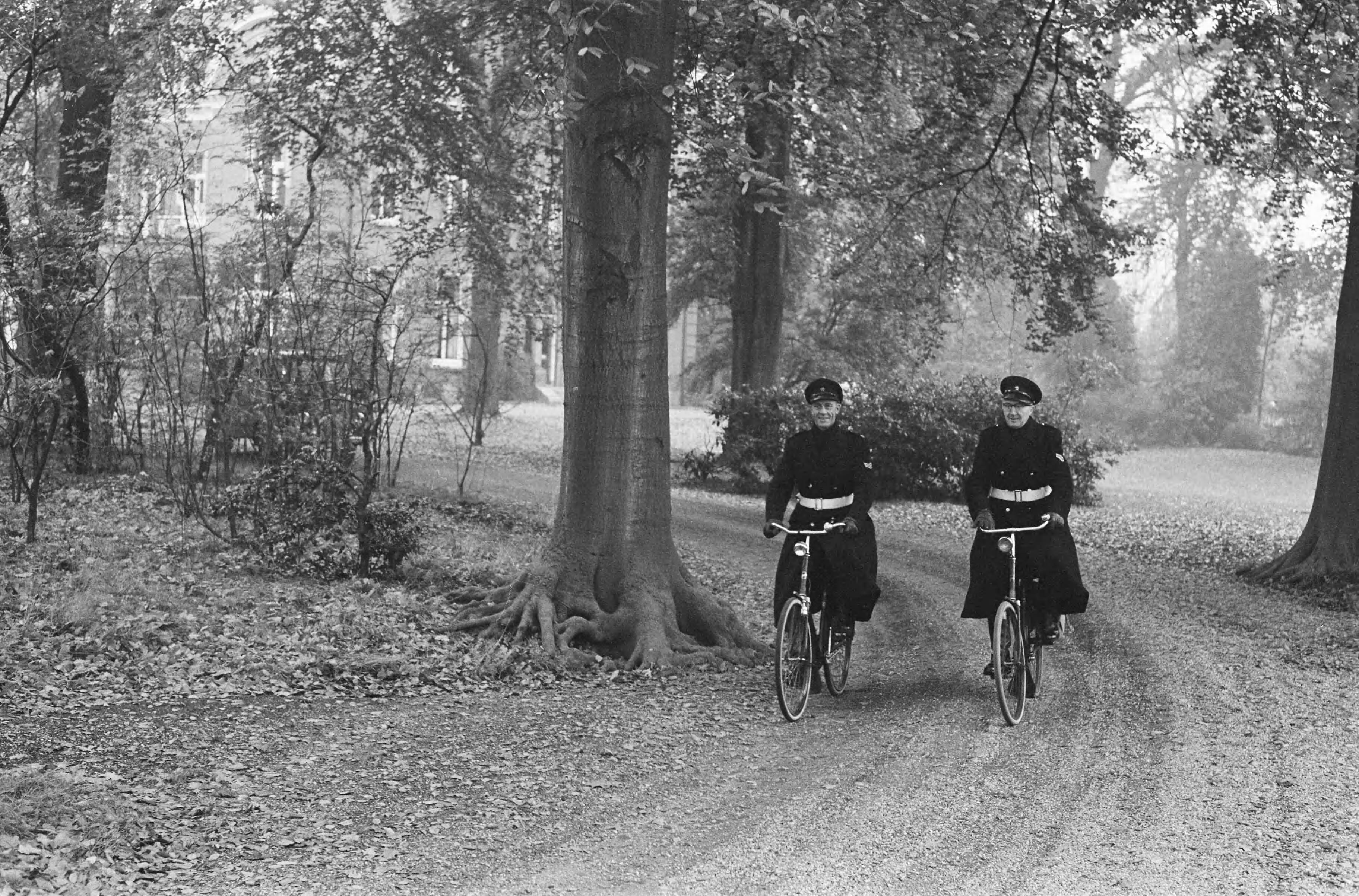 Fotocollectie Anefo — Drukte in Baarn in verband met ontsnapping moordenaar. Twee politieagenten op de fiets — Foto: Rossem, Wim van / Anefo. Licentie: Set B: Rechtenvrij / Publiek Domein. Bron: Nationaal Archief. http://hdl.handle.net/10648/a9eb470c-d0b4-102d-bcf8-003048976d84