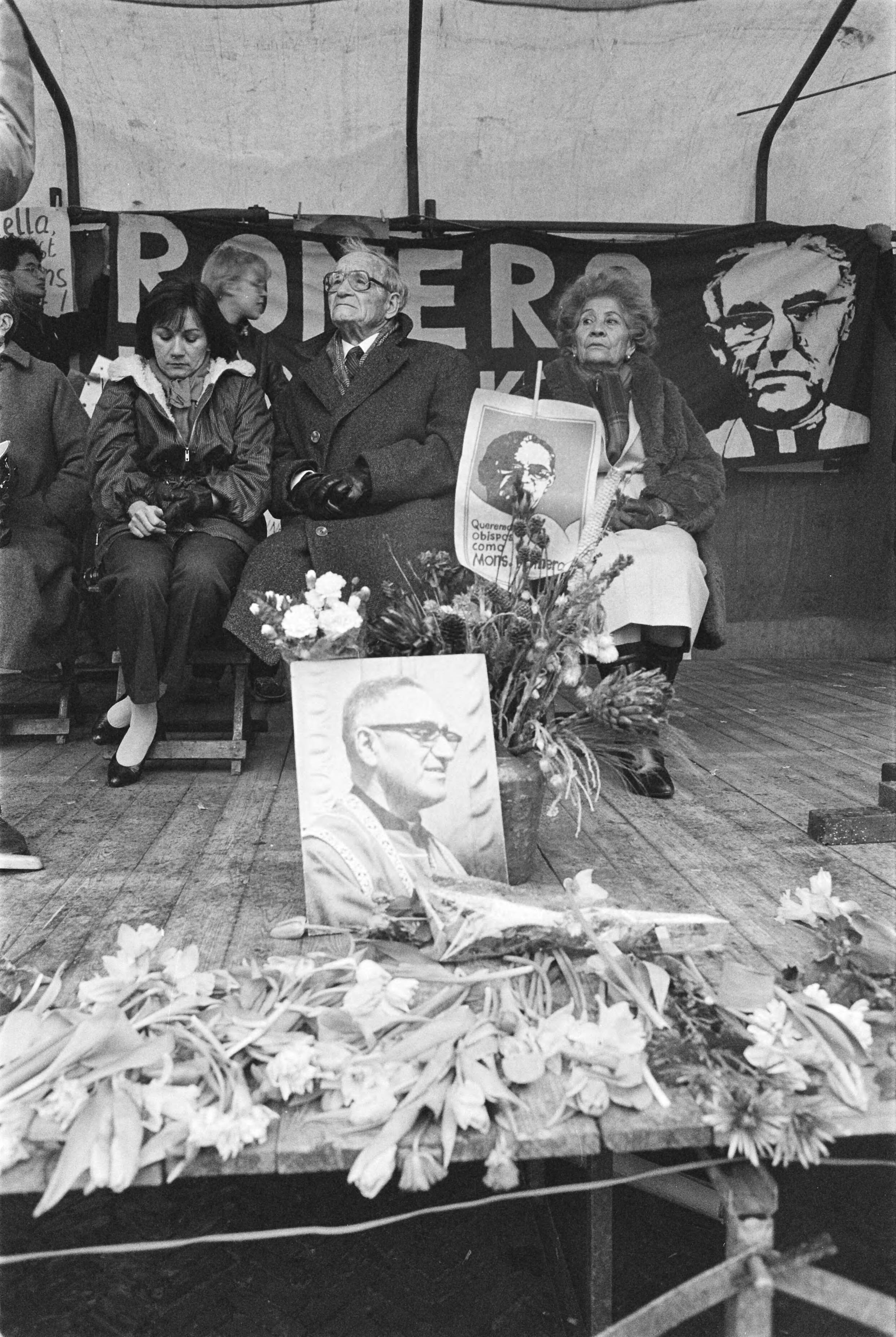 Fotocollectie Anefo — Herdenking vermoorde bisschop Romero ( El Salvador ) in Den Haag ; ouders en zuster Marianella bij portret Romero — Foto: Croes, Rob C. / Anefo. Licentie: Set B: Rechtenvrij / Publiek Domein. Bron: Nationaal Archief. http://hdl.handle.net/10648/ad3663c4-d0b4-102d-bcf8-003048976d84