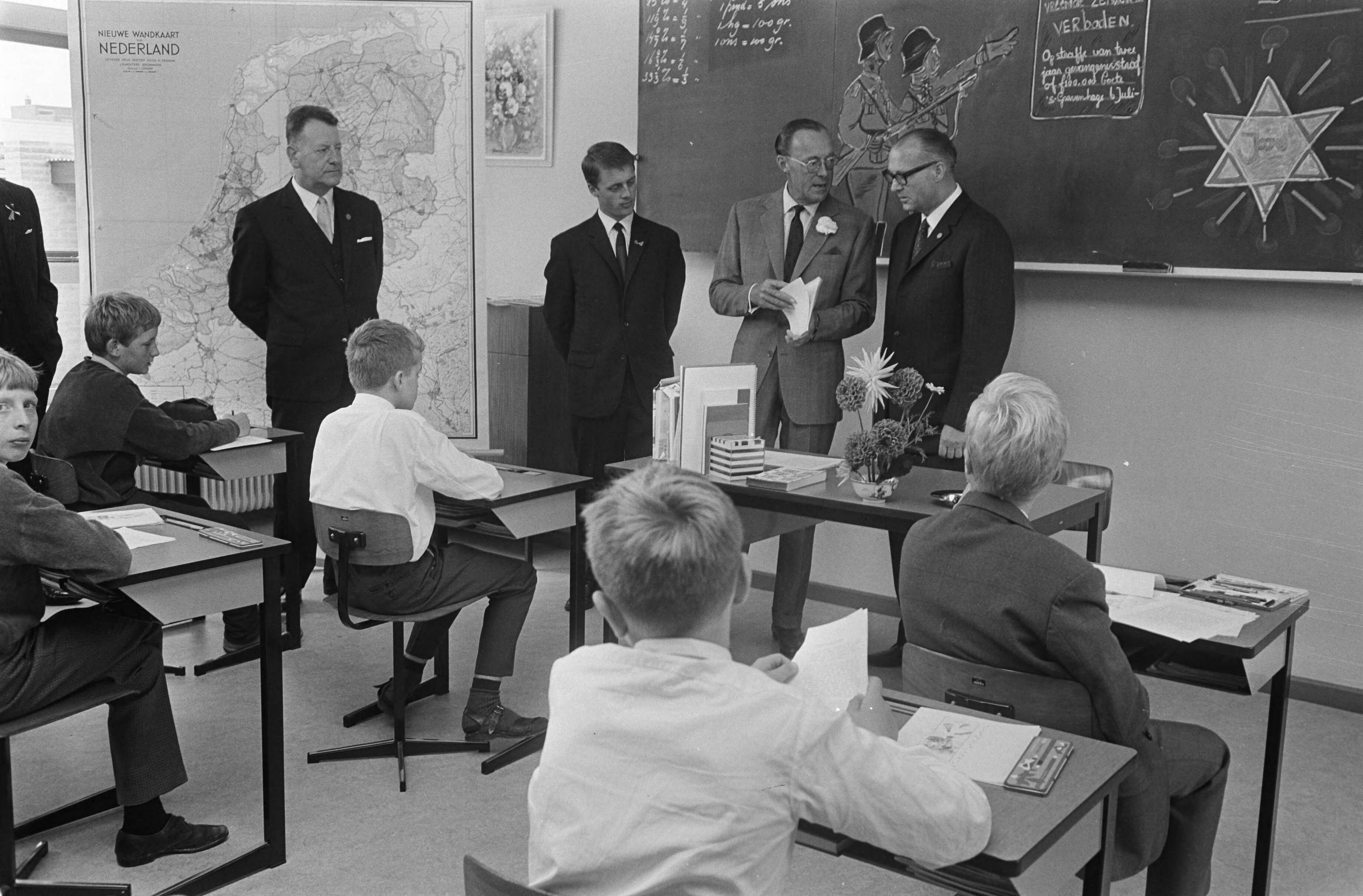 Prins Bernhard opent de Prins Bernhard school te Leeuwarden — De Prins is op bezoek in een klas — Foto: Fotograaf Onbekend / Anefo. Licentie: Set B: Rechtenvrij / Publiek Domein. Bron: Nationaal Archief. http://hdl.handle.net/10648/ab4c46be-d0b4-102d-bcf8-003048976d84