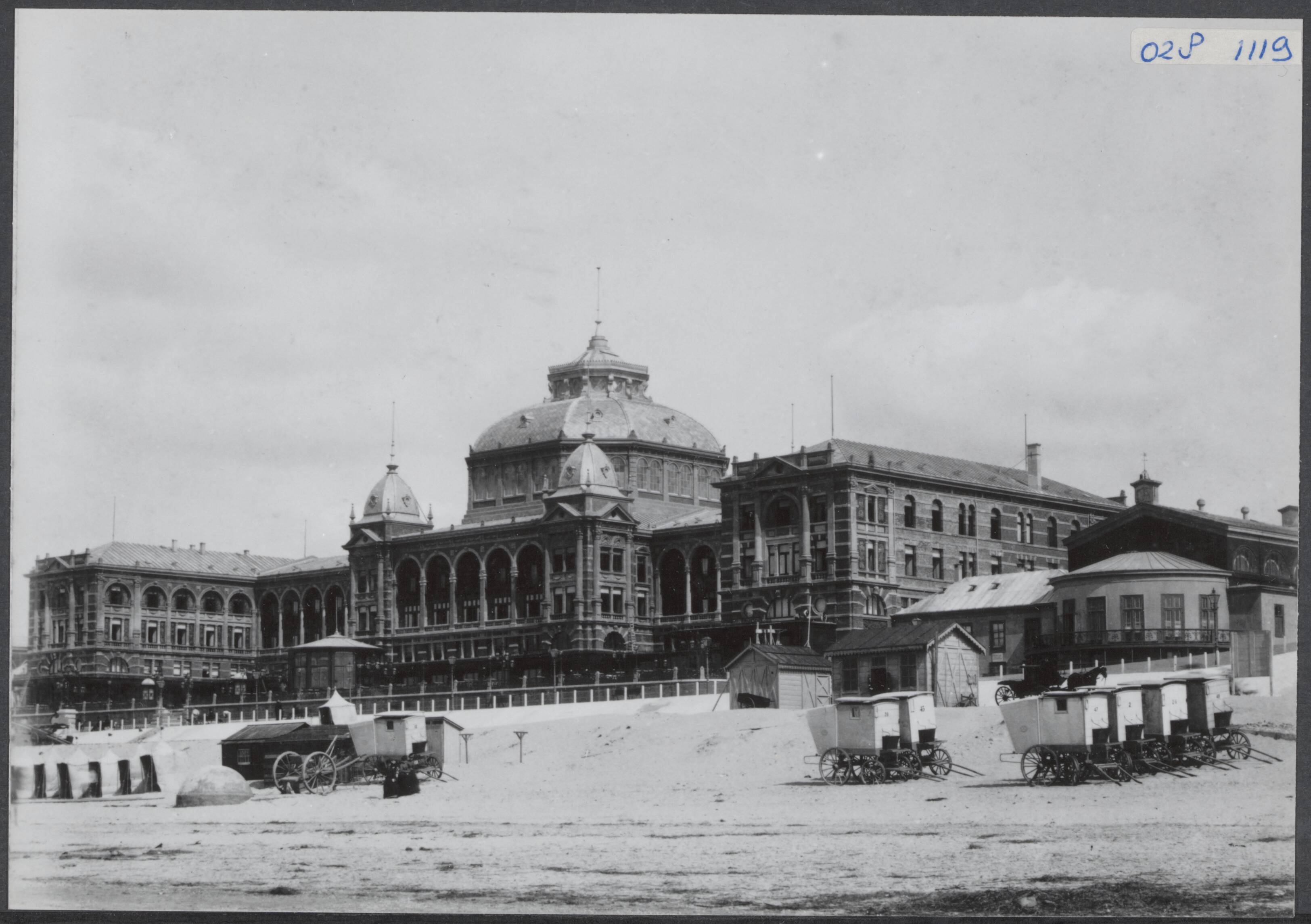 Fotocollectie Elsevier Binnenland — Kurhaus te Scheveningen. Gezicht vanaf het strand met badkoetsjes — Foto: Onbekend / Publiek Domein of Rechtenvrij. Licentie: Set B: Rechtenvrij / Publiek Domein. Bron: Nationaal Archief. http://hdl.handle.net/10648/addfd206-d0b4-102d-bcf8-003048976d84