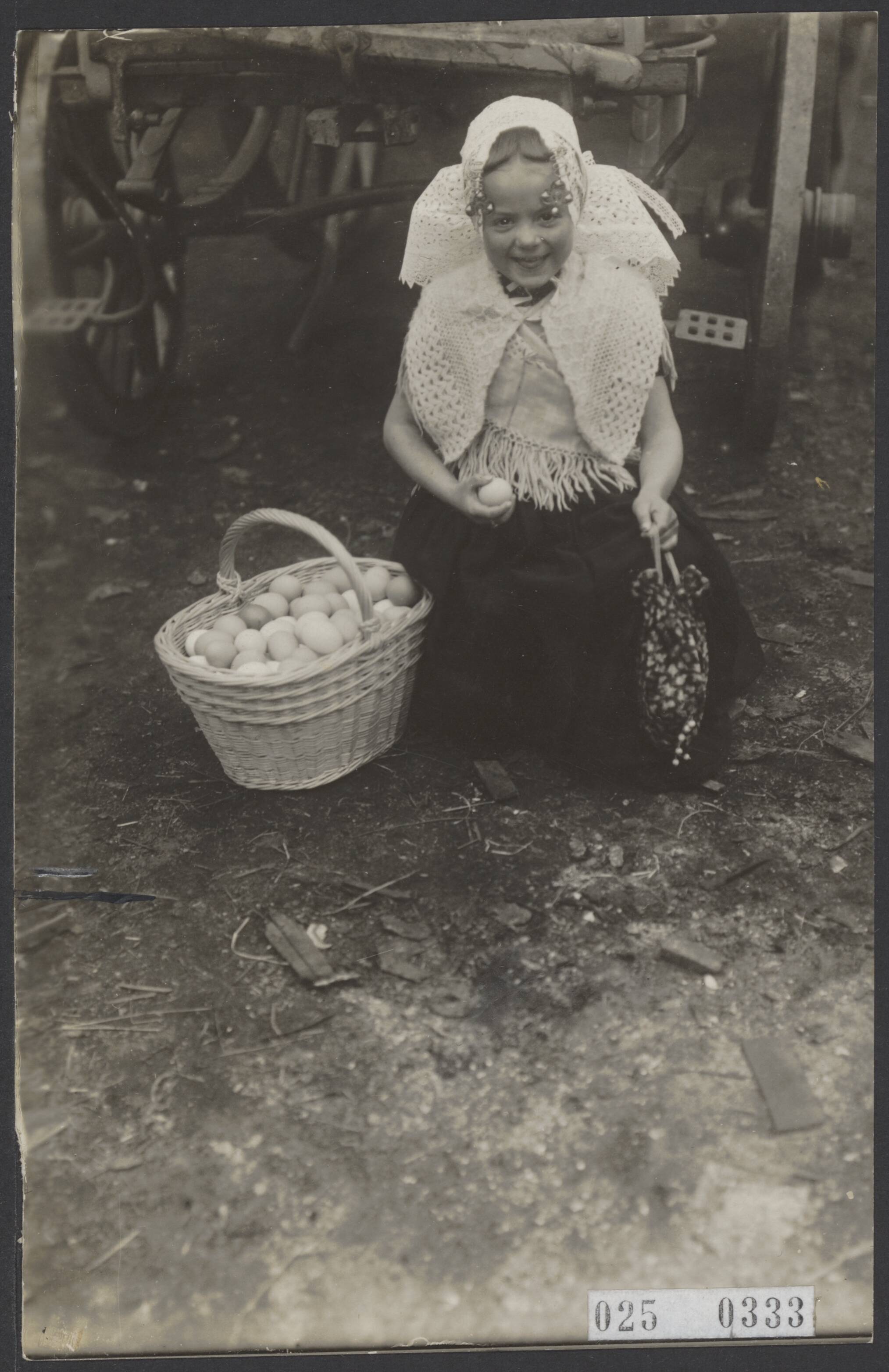 Fotocollectie Elsevier Binnenland — Meisje in klederdracht uit Oostkapelle met een mand eieren — Foto: Onbekend / Publiek Domein of Rechtenvrij. Licentie: Set B: Rechtenvrij / Publiek Domein. Bron: Nationaal Archief. http://hdl.handle.net/10648/adda3b52-d0b4-102d-bcf8-003048976d84