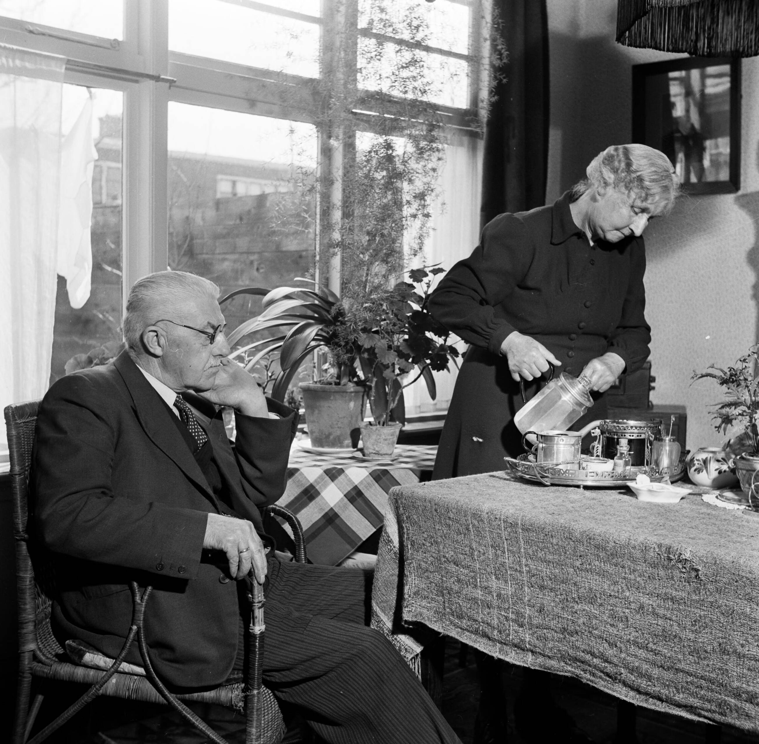 Fotocollectie Van de Poll — Het echtpaar S. de Jong in hun woonkamer in het Friese Huizum (nu deel van Leeuwarden) — Foto: Poll, Willem van de. Licentie: Set B: Rechtenvrij / Publiek Domein. Bron: Nationaal Archief. http://hdl.handle.net/10648/aeccc20a-d0b4-102d-bcf8-003048976d84