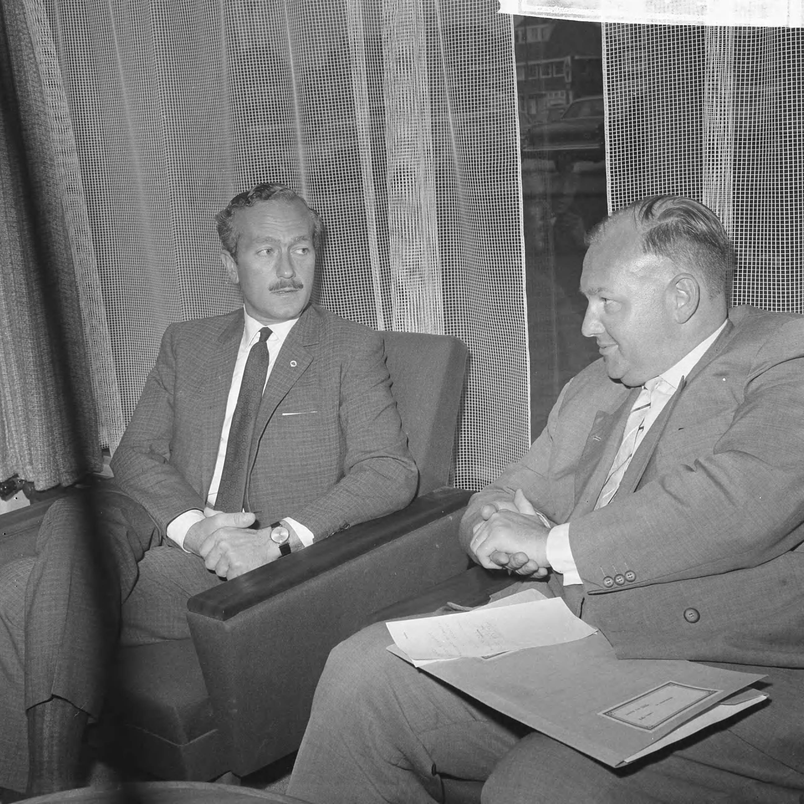 Fotocollectie Anefo — Colin Chapman, de manager van [autocoureur] Jim Clark, die door de Zandvoortse politie was gearresteerd, is door de Officier van Justitie te Haarlem vrijgelaten, op voorwaarde dat hij op 20 juli zal verschijnen voor de politierechter. Na zijn vrijlating ging Chapman (links) naar het Bouwes Palace Hotel te Zandvoort waar hij enige persvertegenwoordigers te woord stond. Naast hem zijn advocaat mr. A.S. Groen — Foto: Evers, Joost / Anefo. Licentie: Set B: Rechtenvrij / Publiek Domein. Bron: Nationaal Archief. http://hdl.handle.net/10648/aab5197e-d0b4-102d-bcf8-003048976d84