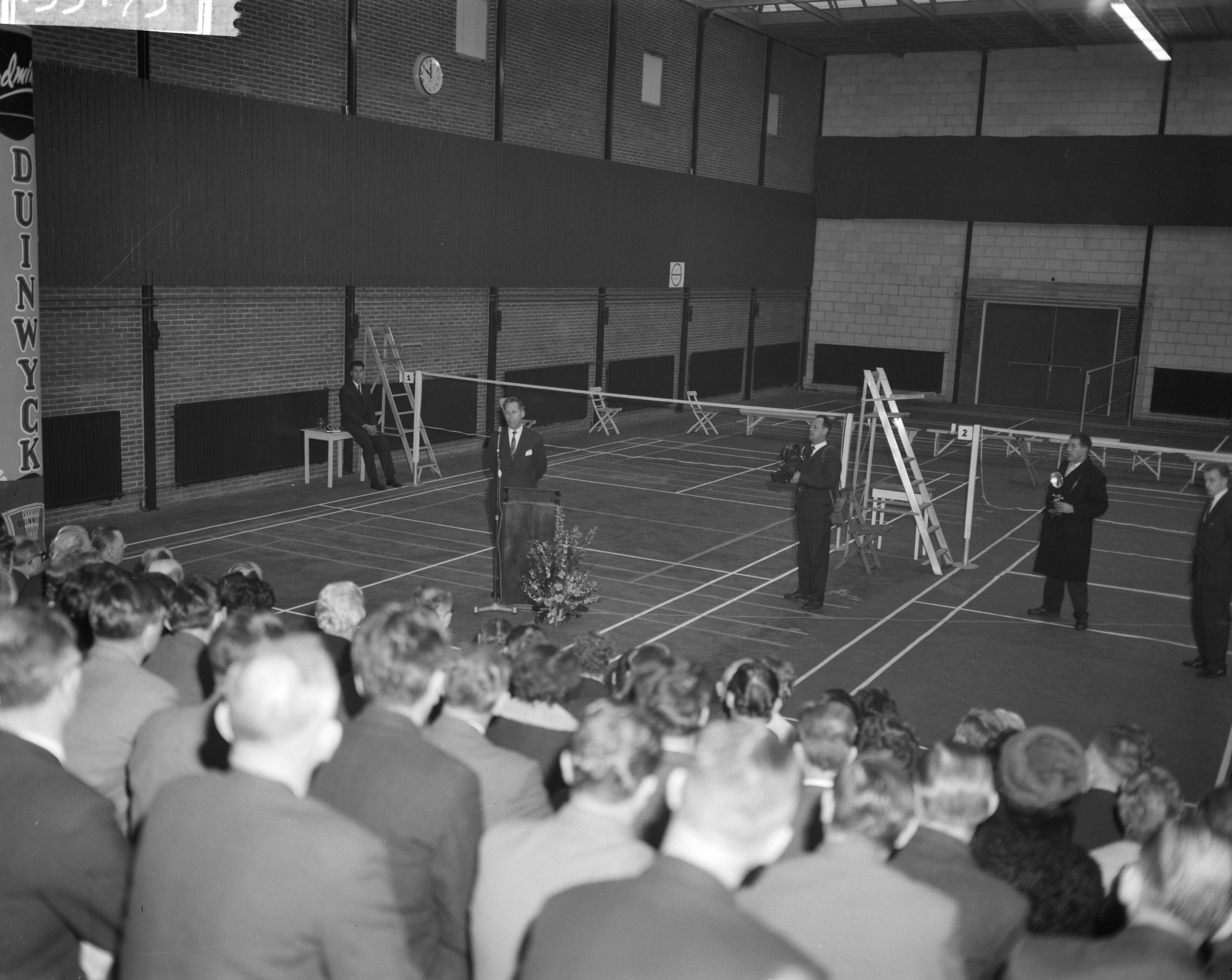Fotocollectie Anefo — Opening "Duinwijck" badmintonhal aan de Klevenlaan te Haarlem met openingsrede van wethouder D.J.A. Geluk — Foto: Bilsen, Joop van / Anefo. Licentie: Set B: Rechtenvrij / Publiek Domein. Bron: Nationaal Archief. http://hdl.handle.net/10648/a9f8ac4e-d0b4-102d-bcf8-003048976d84