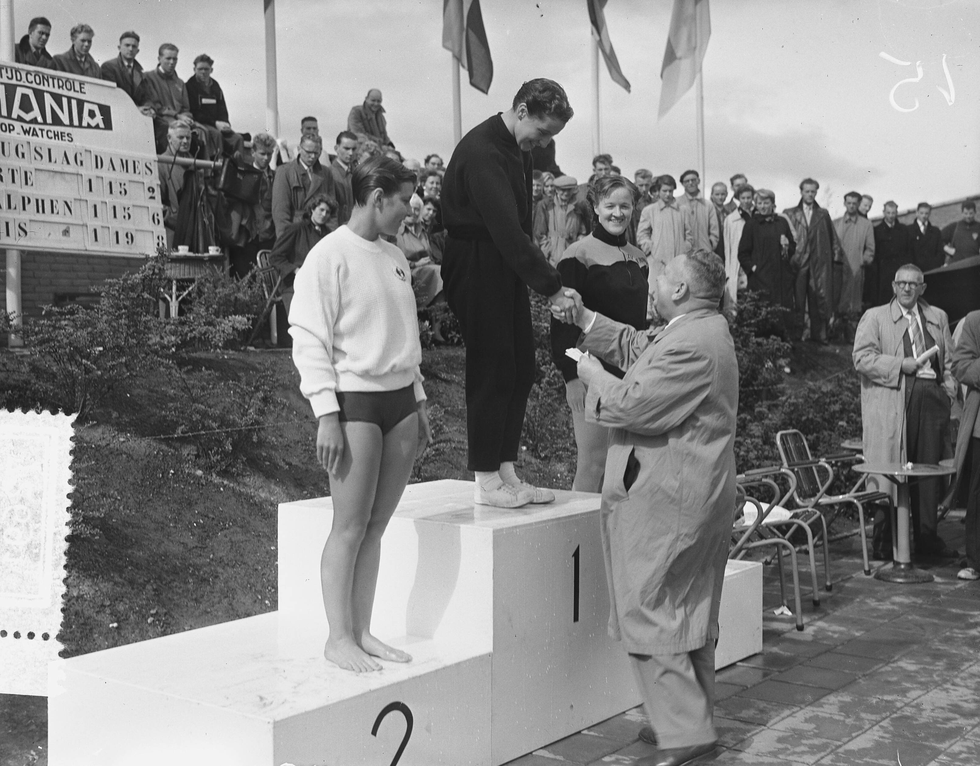 Fotocollectie Anefo — Nederlandse kampioenschappen zwemmen te Groningen, Huldiging 100 m rugslag dames. Winnares Joke de Korte wordt gefeliciteerd. Rechts Jopie van Alphen (2e) en links Dicky van Ekris (3e) — Foto: Bilsen, Joop van / Anefo. Licentie: Set B: Rechtenvrij / Publiek Domein. Bron: Nationaal Archief. http://hdl.handle.net/10648/a9394124-d0b4-102d-bcf8-003048976d84