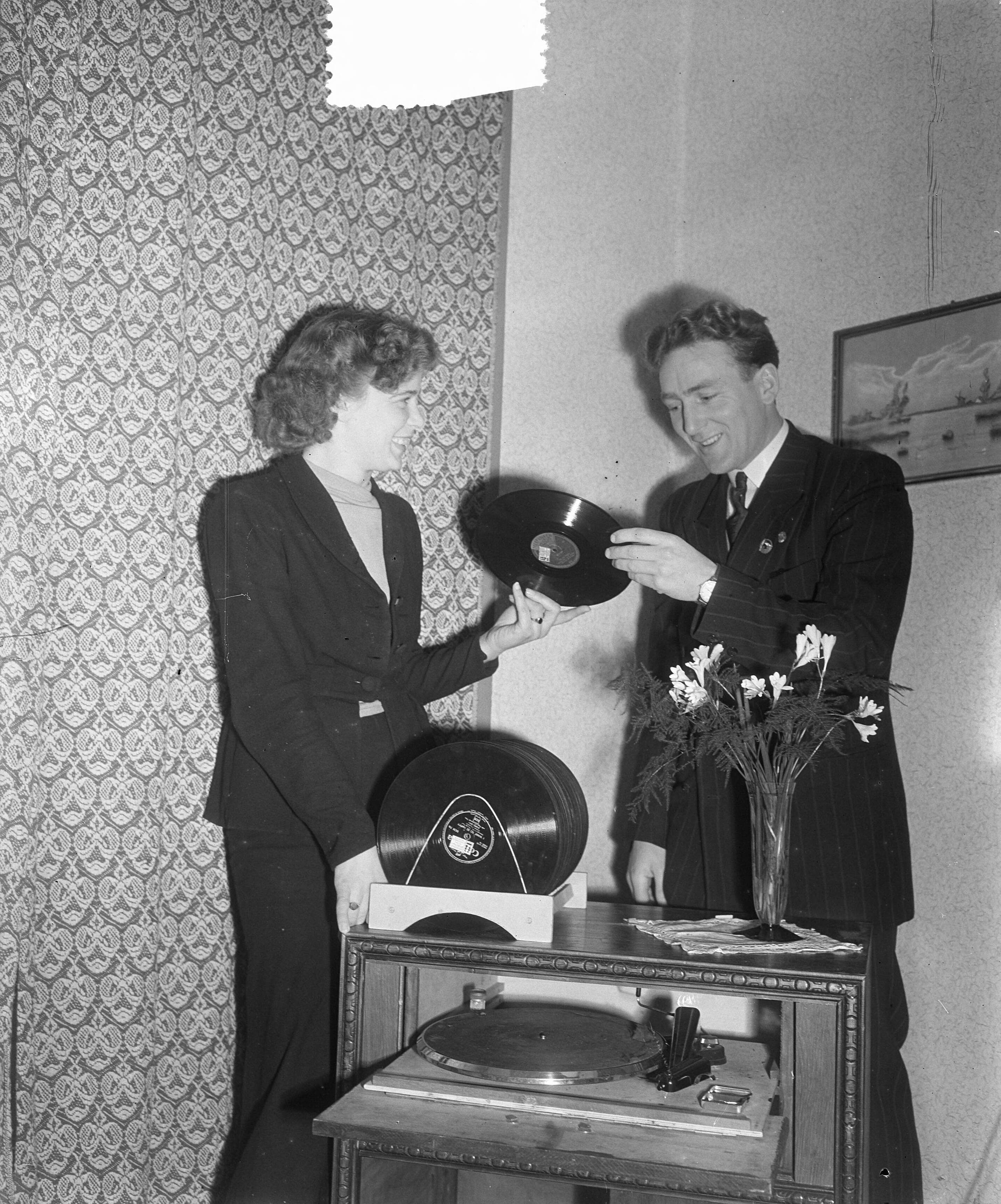Reportage voetballer Louis Biesbrouck — Voetballer Louis Biesbrouck thuis in Haarlem. Bekijkt met zijn vrouw grammofoonplaten — Foto: Duinen, H. van / Anefo. Licentie: Set B: Rechtenvrij / Publiek Domein. Bron: Nationaal Archief. http://hdl.handle.net/10648/a8f49f7e-d0b4-102d-bcf8-003048976d84