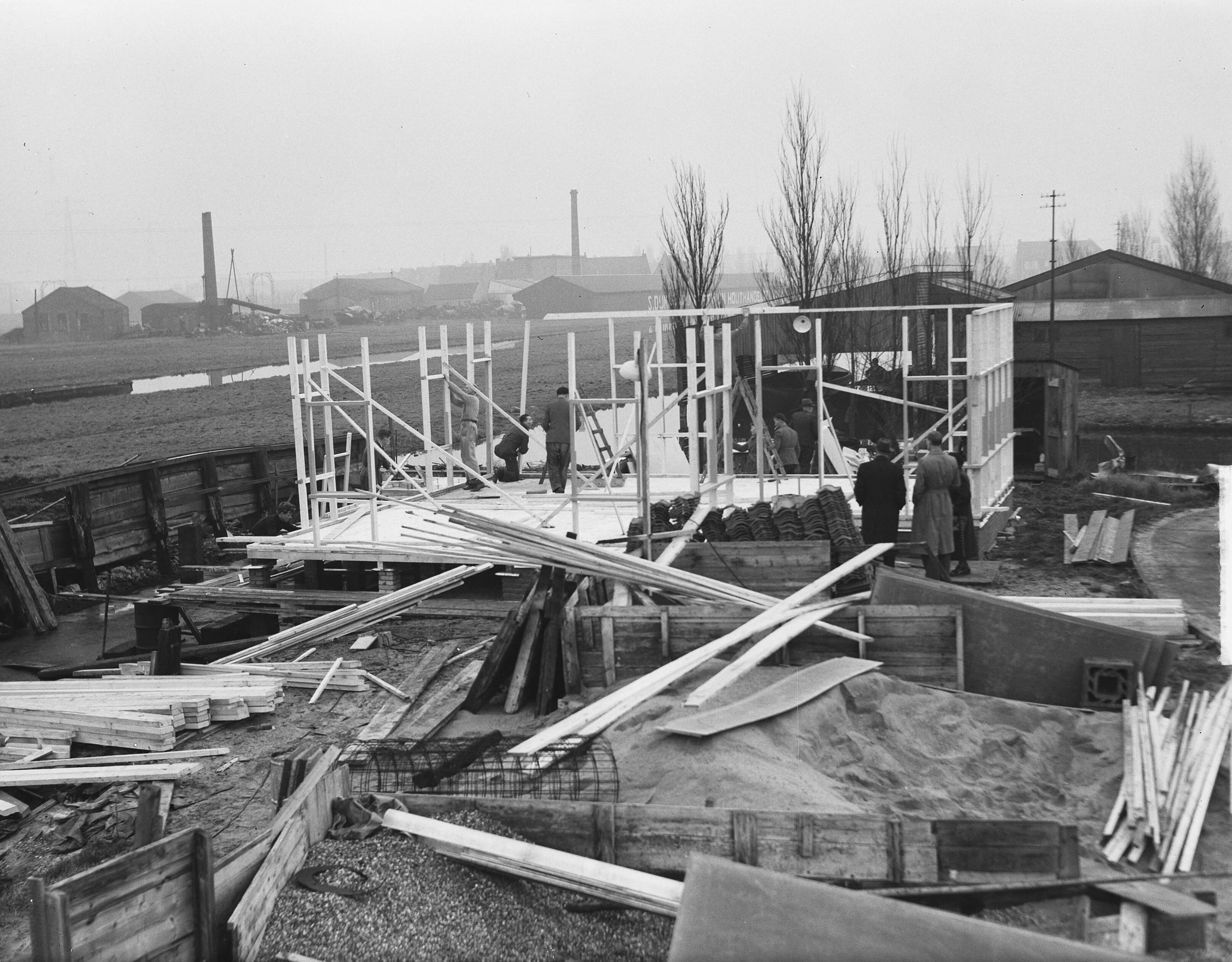 Fotocollectie Anefo — Demonstratie van een bouwpakket "emigrantenwoning" door een aannemingsbedrijf in Zaandam. De woning is bedoeld voor emigranten naar o.a. Australië en kan in een dag opgebouwd worden — Foto: Oorschot, […] van / Anefo. Licentie: Set B: Rechtenvrij / Publiek Domein. Bron: Nationaal Archief. http://hdl.handle.net/10648/a8e602a2-d0b4-102d-bcf8-003048976d84