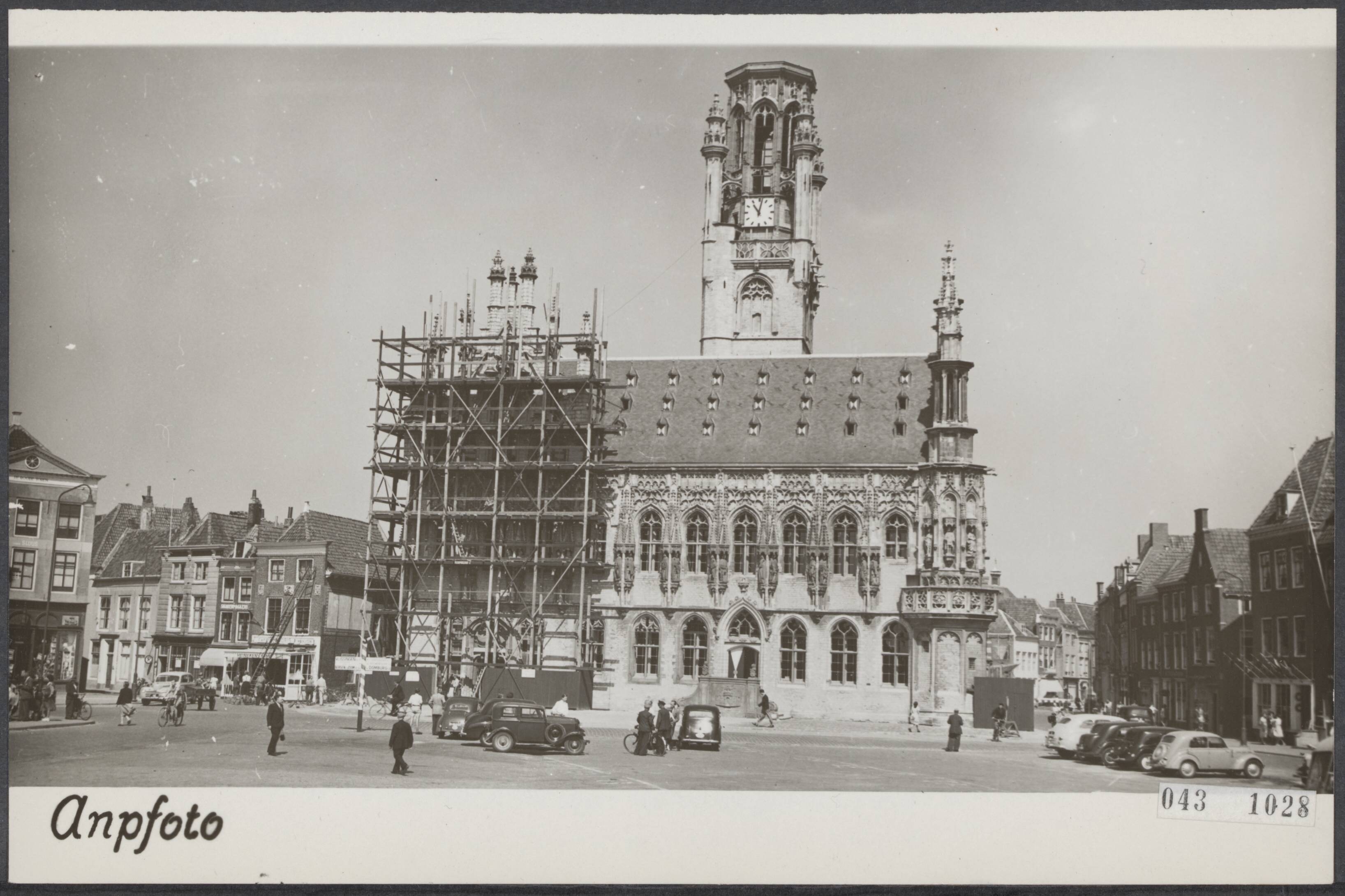 Fotocollectie Elsevier Binnenland — Wederopbouw van het stadhuis van Middelburg nadat het gebouw geheel was uitgebrand als gevolg van oorlogshandelingen. De voorgevel met de beelden van 25 graven en gravinnen van Zeeland. Slechts een klein gedeelte staat nog in de steigers — Foto: ANP / RVD of rechtenvrij. Licentie: Set B: Rechtenvrij / Publiek Domein. Bron: Nationaal Archief. http://hdl.handle.net/10648/adf9e10a-d0b4-102d-bcf8-003048976d84