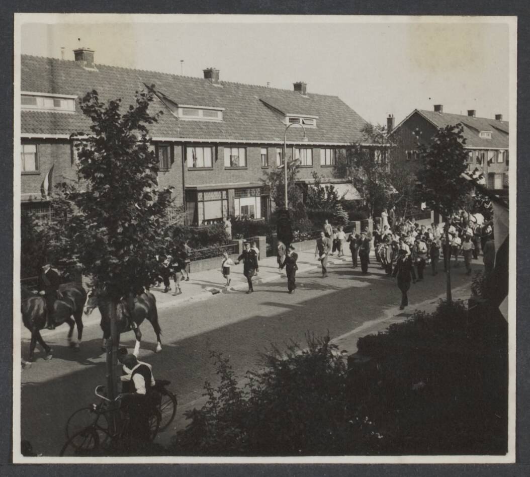 Bevrijding Nederland 1944 [bevat ook foto's uit 1945] — Bevrijdingsfeest Leidschendam [een optocht door een straat, voorafgegaan door ruiters en een muziekkapel. Politie loopt mee] — Foto: Onbekend / Publiek Domein of Rechtenvrij. Licentie: Set B: Rechtenvrij / Publiek Domein. Bron: Nationaal Archief. http://hdl.handle.net/10648/5327380f-b531-73ec-1bd6-79d6cbb909b2