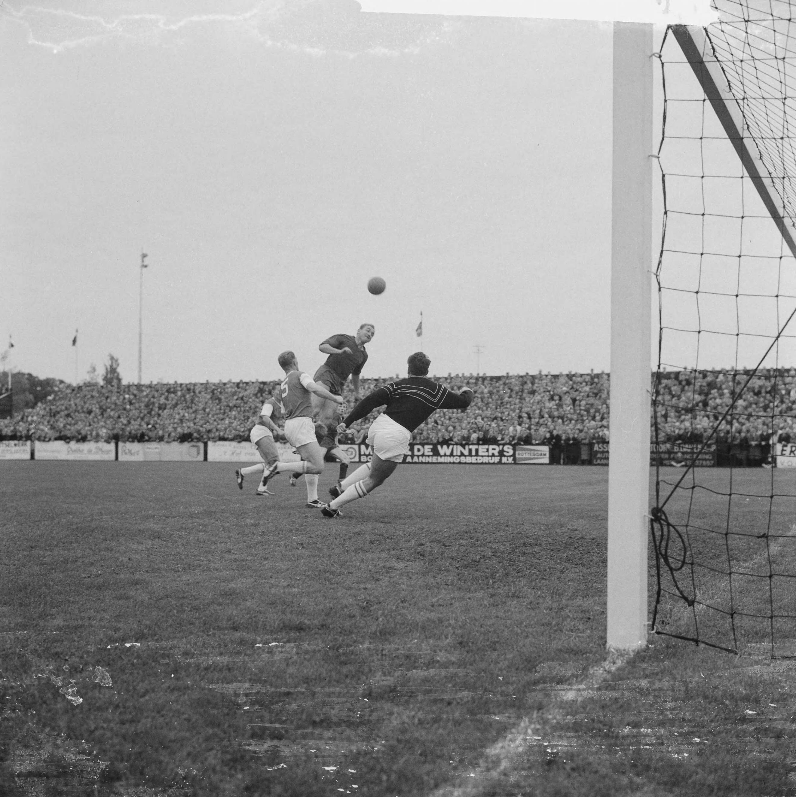 Fotocollectie Anefo — Voetbal. RHC tegen Haarlem 1-1. Spelmoment voor RHC doel. Koppend Henk Angenent (Haarlem), in het doel RCH reserve-keeper Peter Huijer — Foto: Koch, Eric / Anefo. Licentie: Set B: Rechtenvrij / Publiek Domein. Bron: Nationaal Archief. http://hdl.handle.net/10648/aa1977e4-d0b4-102d-bcf8-003048976d84