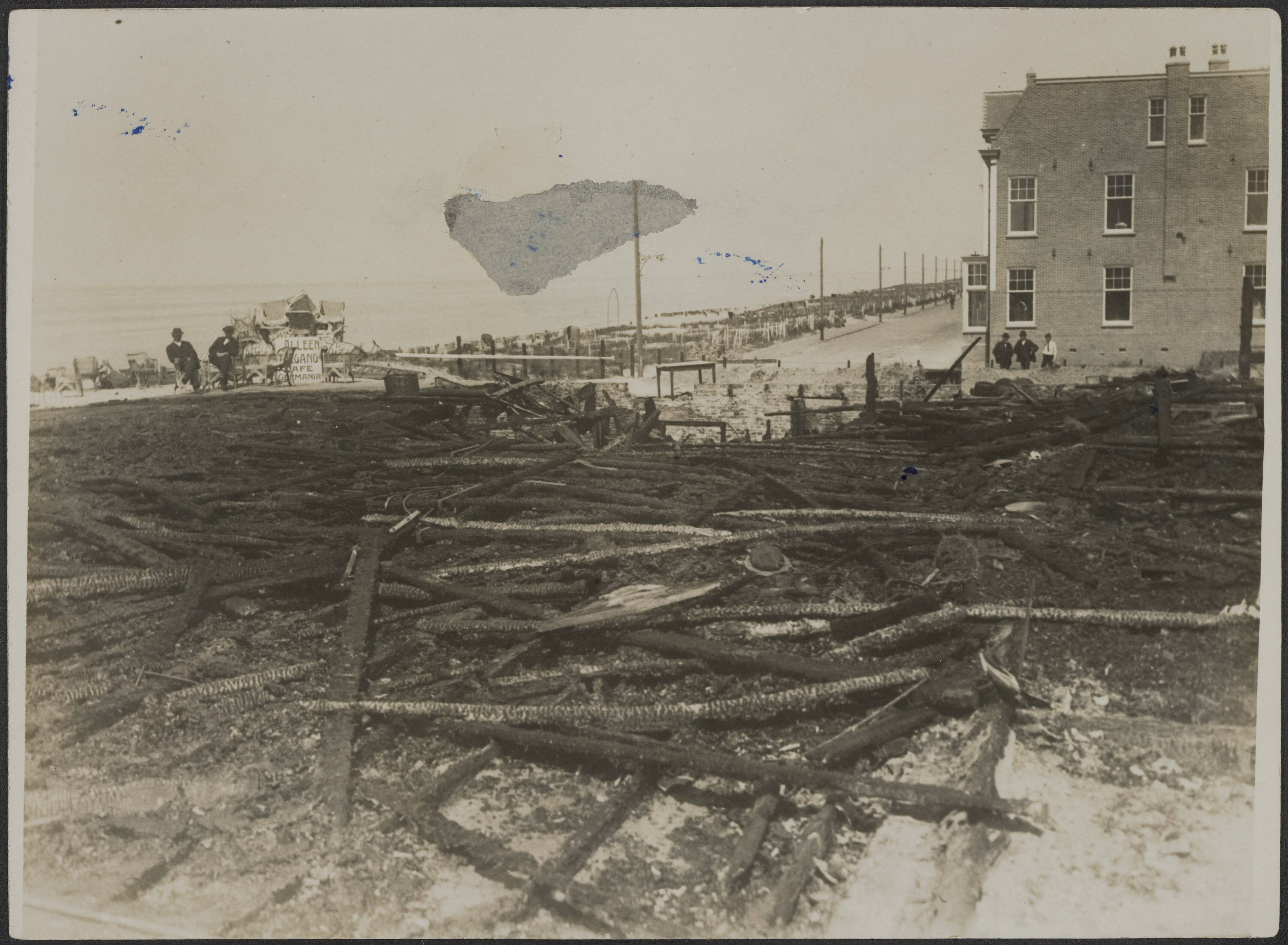 Fotocollectie Eerste Wereldoorlog — Brand Café Germania te Zandvoort. Burgers kijken naar de restanten. — Foto: N.V. Vereenigde Fotobureaux. Licentie: Set B: Rechtenvrij / Publiek Domein. Bron: Nationaal Archief. http://hdl.handle.net/10648/af97fa1a-d0b4-102d-bcf8-003048976d84