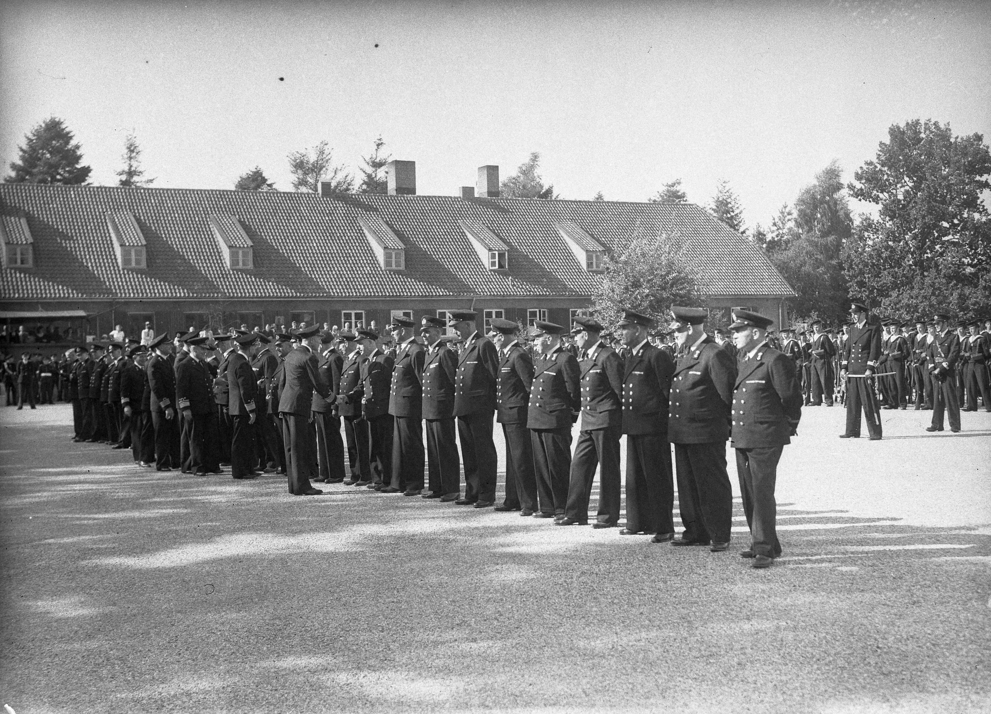 Fotocollectie Anefo — Beëdiging van 29 marine-officieren op het Marine Opleidingskamp te Hilversum. De Commandant der Marine Schout-bij-nacht J.J.L. Willinge feliciteert de nieuwe officieren — Foto: Sagers, Harry / Anefo. Licentie: Set B: Rechtenvrij / Publiek Domein. Bron: Nationaal Archief. http://hdl.handle.net/10648/a8ac9972-d0b4-102d-bcf8-003048976d84