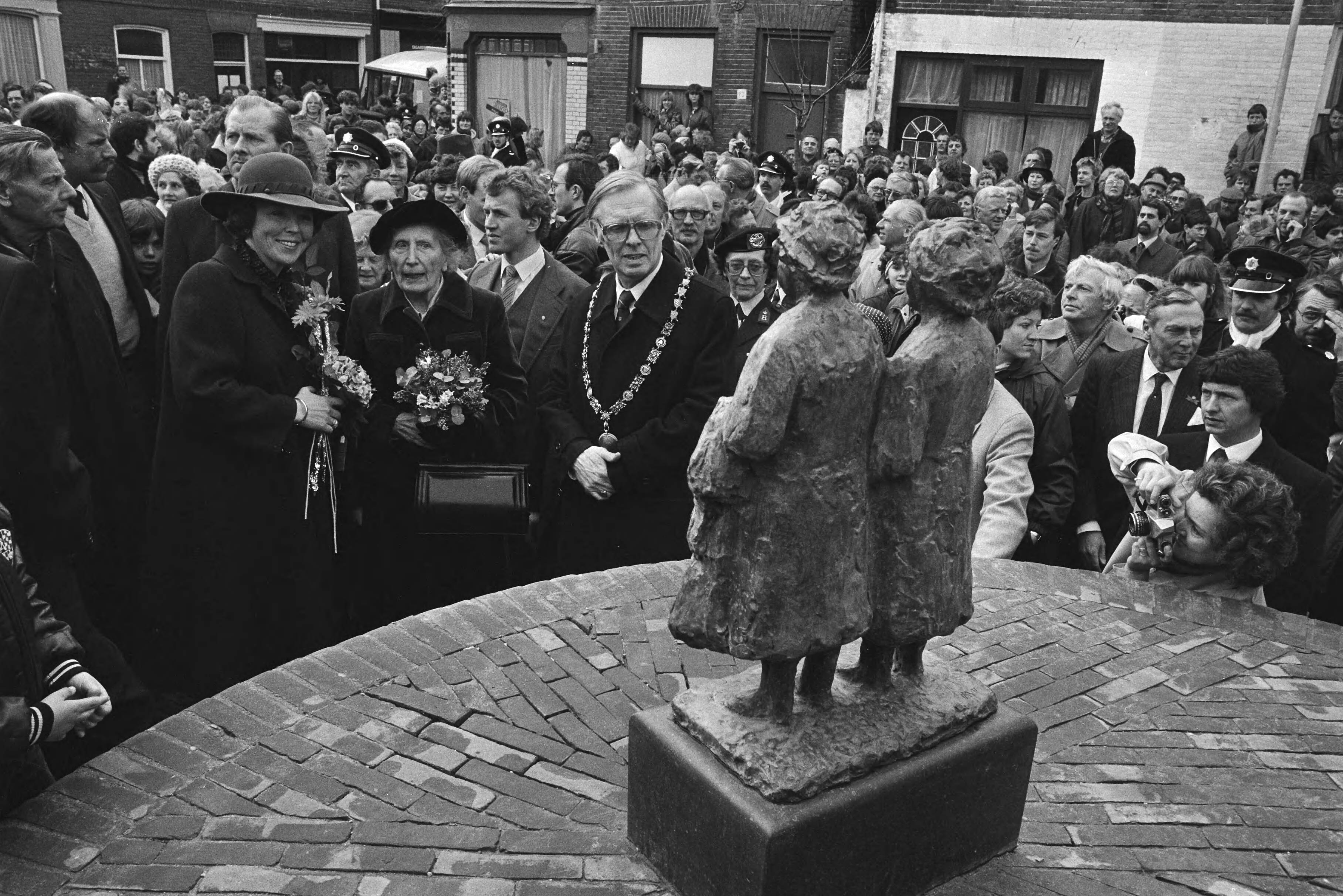Koningin Beatrix bezoekt Haarlem en onthult het beeldje "Tante Jans", dat verwijst naar het behoud van de wijk het Rozenprieel — Haarlem|Noord-Holland|koninginnen |beeldhouwwerken |stadsvernieuwing |burgemeesters|Beatrix, koningin der Nederlanden — Foto: Croes, Rob C. / Anefo. Licentie: Set B: Rechtenvrij / Publiek Domein. Bron: Nationaal Archief. http://hdl.handle.net/10648/ad27b2b6-d0b4-102d-bcf8-003048976d84