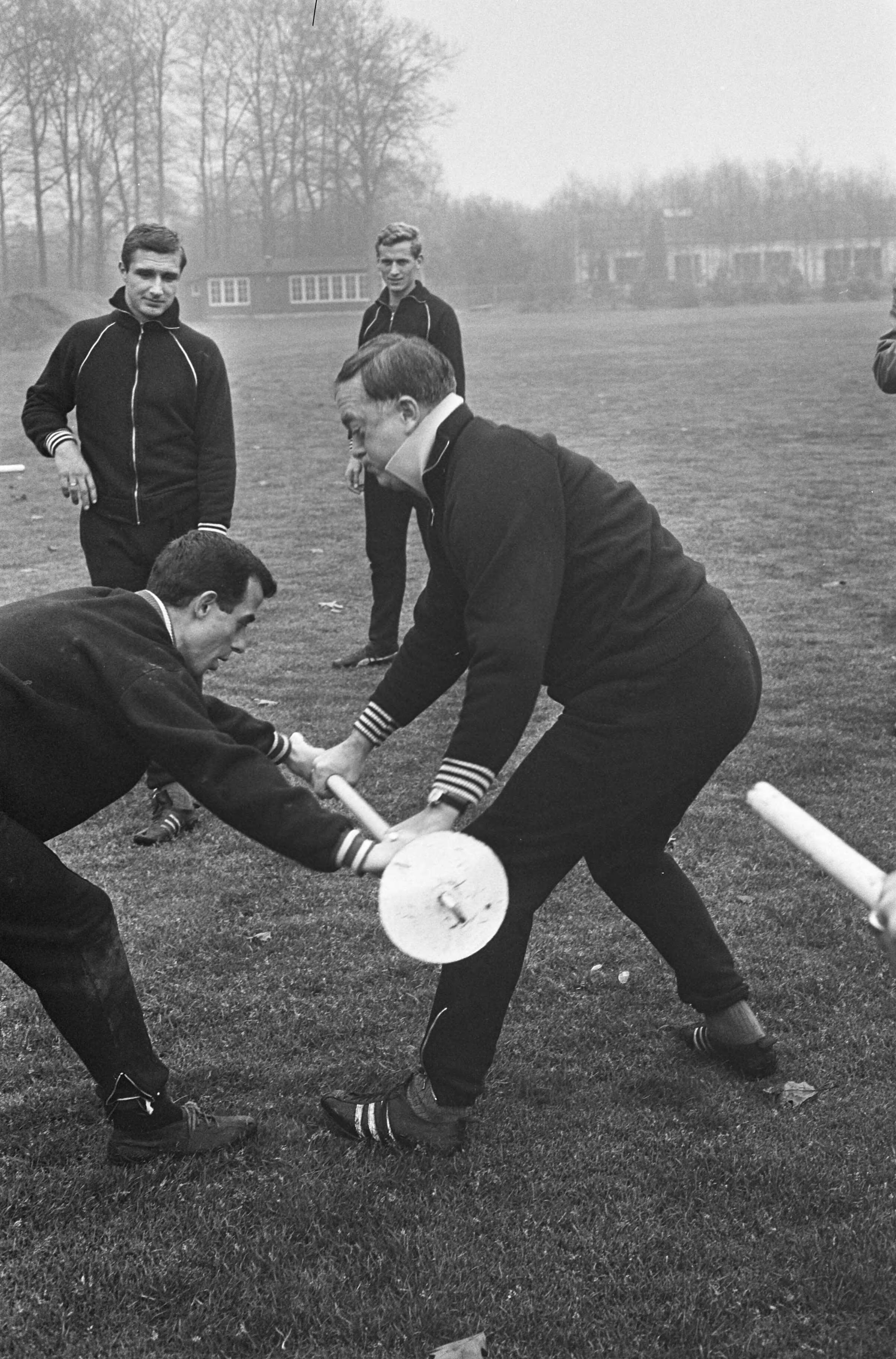 Fotocollectie Anefo — Training Nederlands elftal te Zeist, Coen Moulijn worstelt met Denis Neville, terwijl Cor Veldhoen (links) en Klaas Nuninga toekijken — Foto: Pot, Harry / Anefo. Licentie: Set B: Rechtenvrij / Publiek Domein. Bron: Nationaal Archief. http://hdl.handle.net/10648/aa84927c-d0b4-102d-bcf8-003048976d84